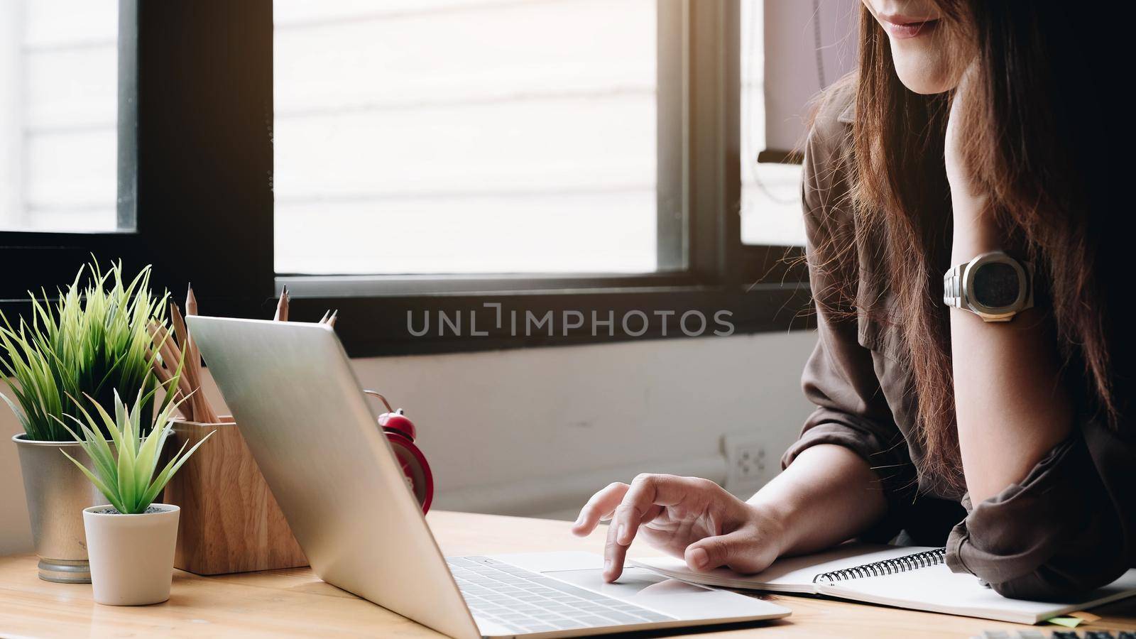 Business woman using laptop computer and calculator for do math finance on wooden desk in office and business working background, tax, accounting, statistics and analytic research concept
