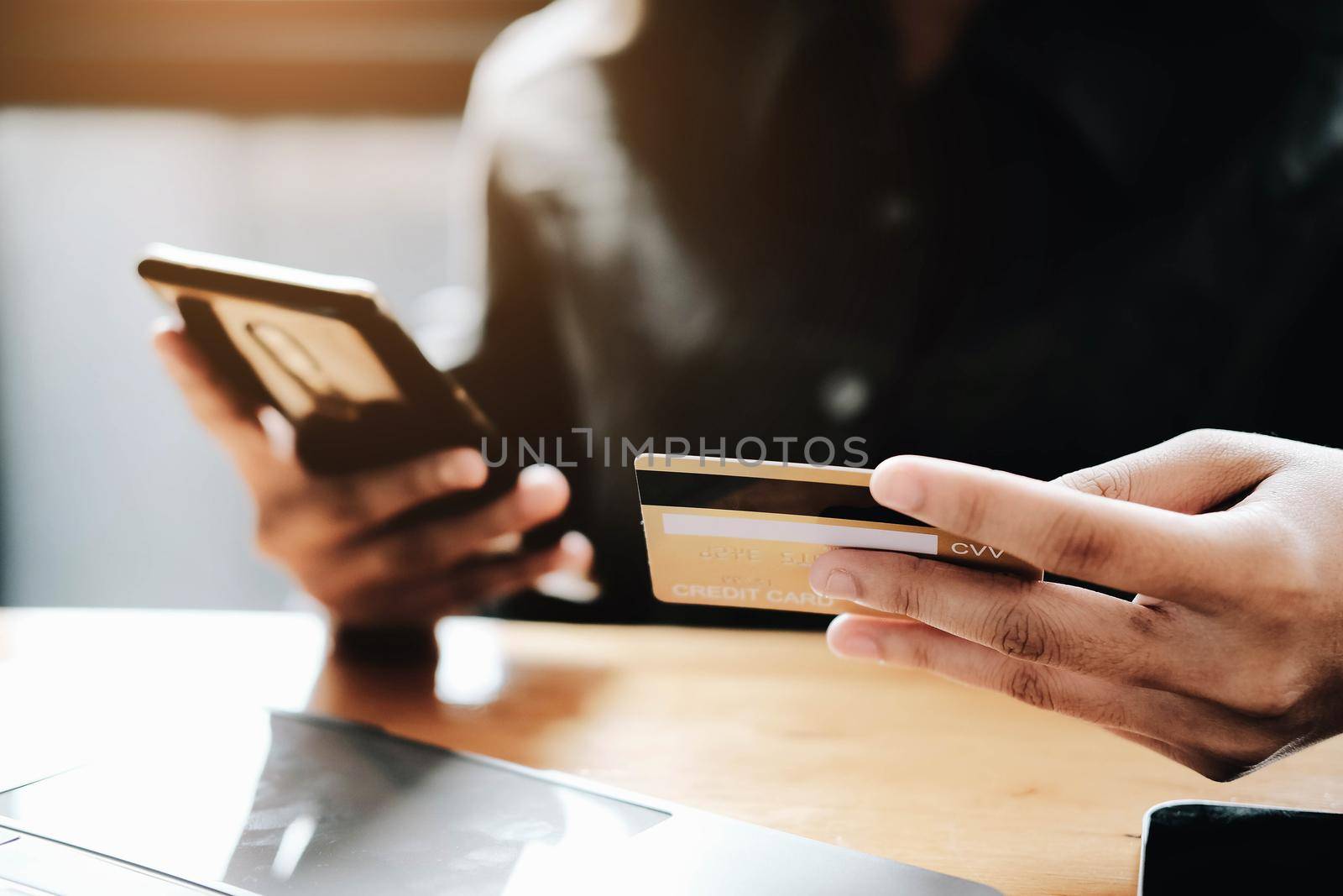 Happy young woman online shopping by credit card payment on mobile smart phone and laptop computer.