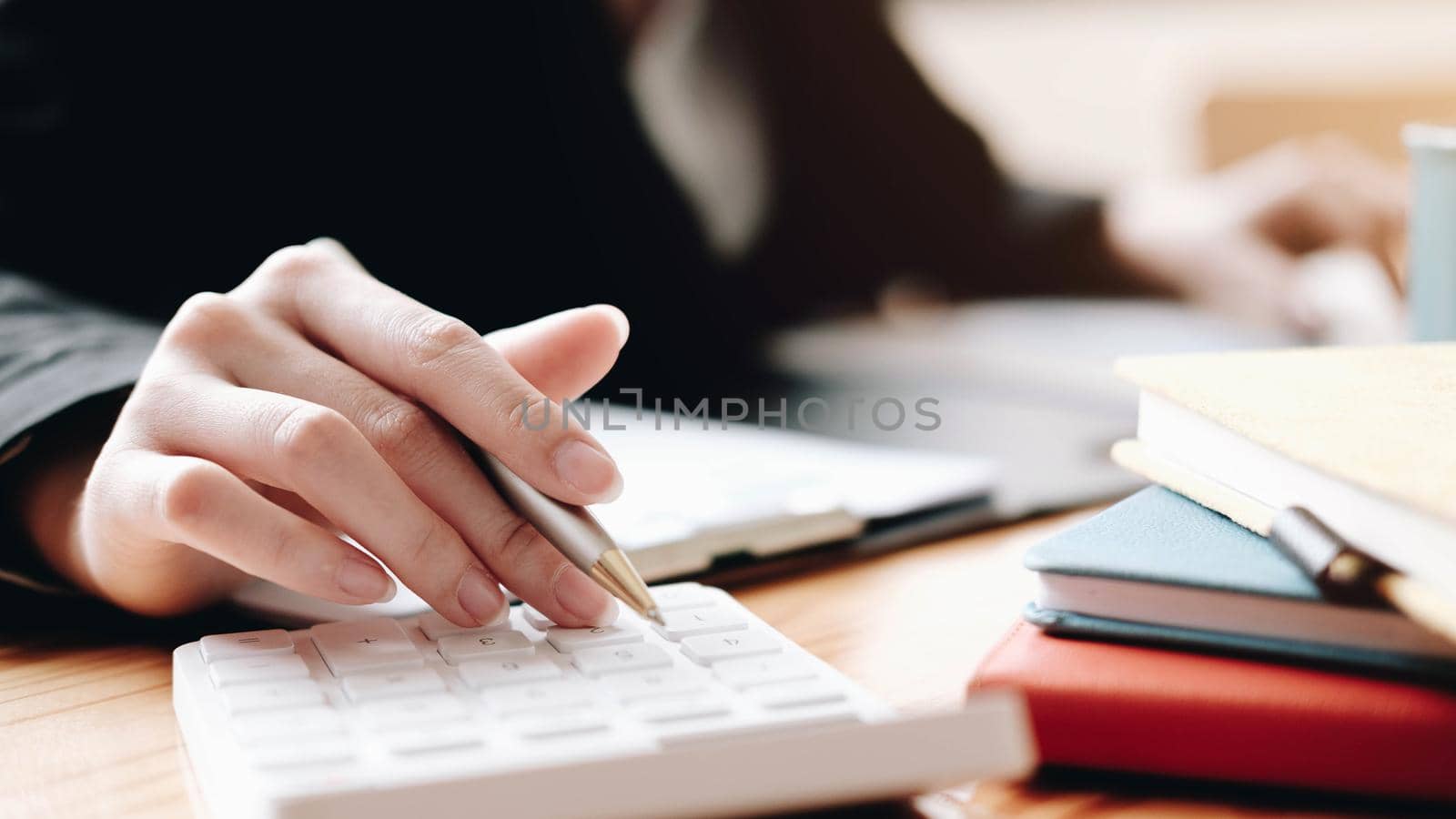 Close up Business woman using calculator and laptop for do math finance on wooden desk in office and business working background tax accounting statistics and analytic research concept
