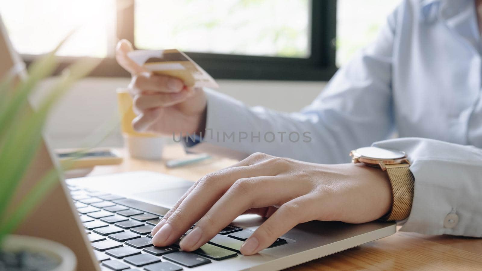 Online payment,woman's hands holding credit card using laptop for online shopping.  by wichayada