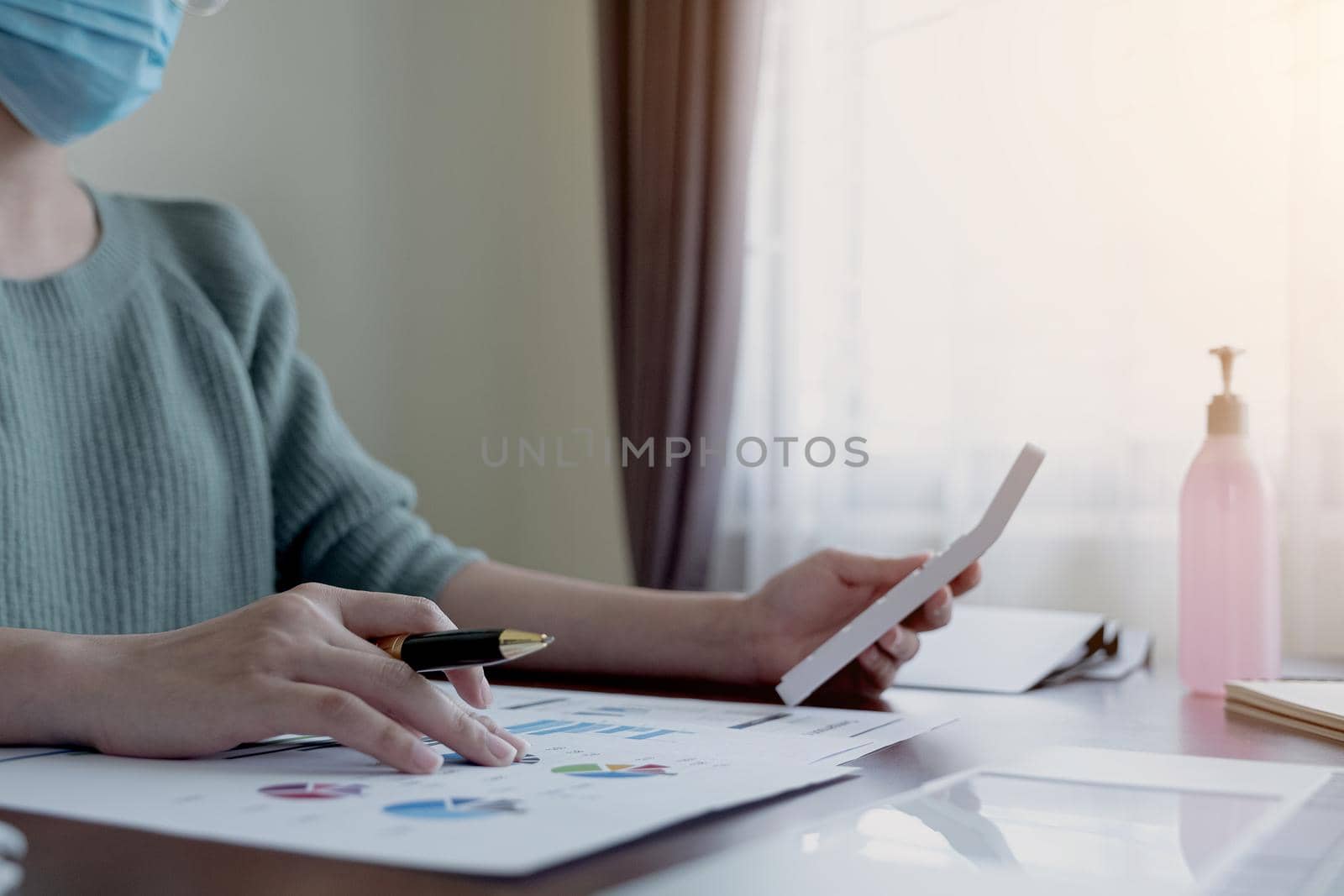 Coronavirus. Business woman working from home wearing protective mask. Business woman in quarantine for coronavirus wearing protective mask. Working from home.  by wichayada