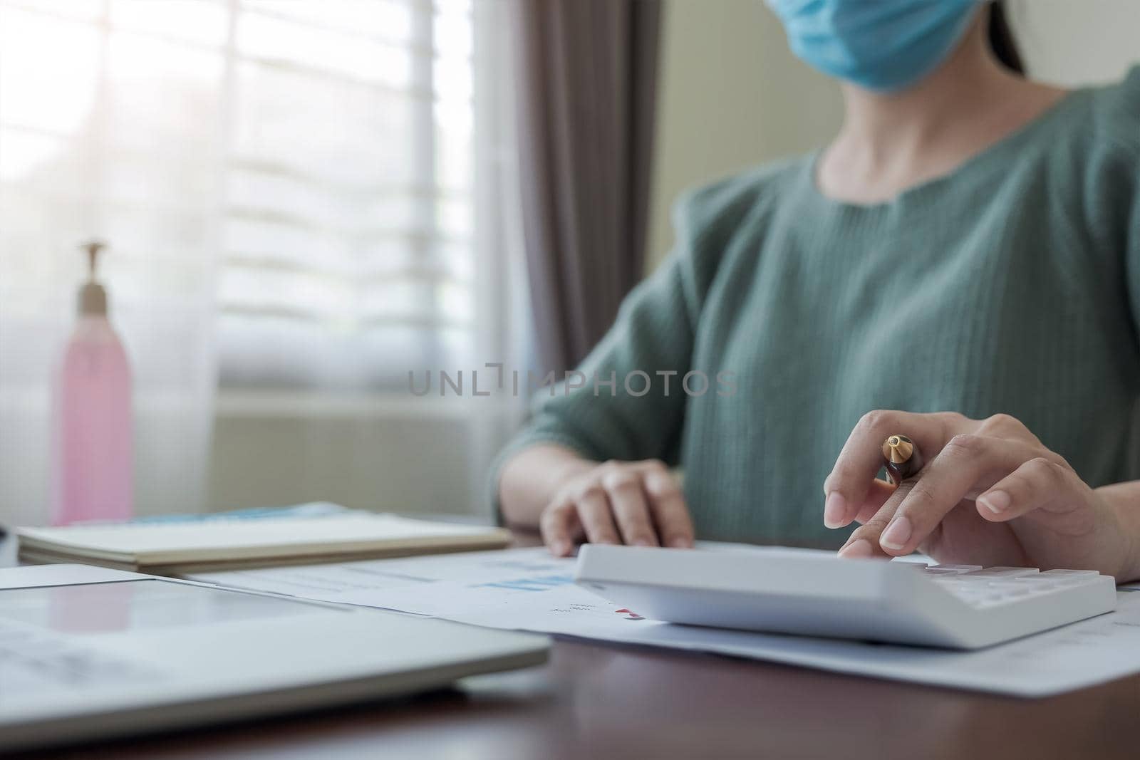Coronavirus. Business woman working from home wearing protective mask. Business woman in quarantine for coronavirus wearing protective mask. Working from home. by wichayada