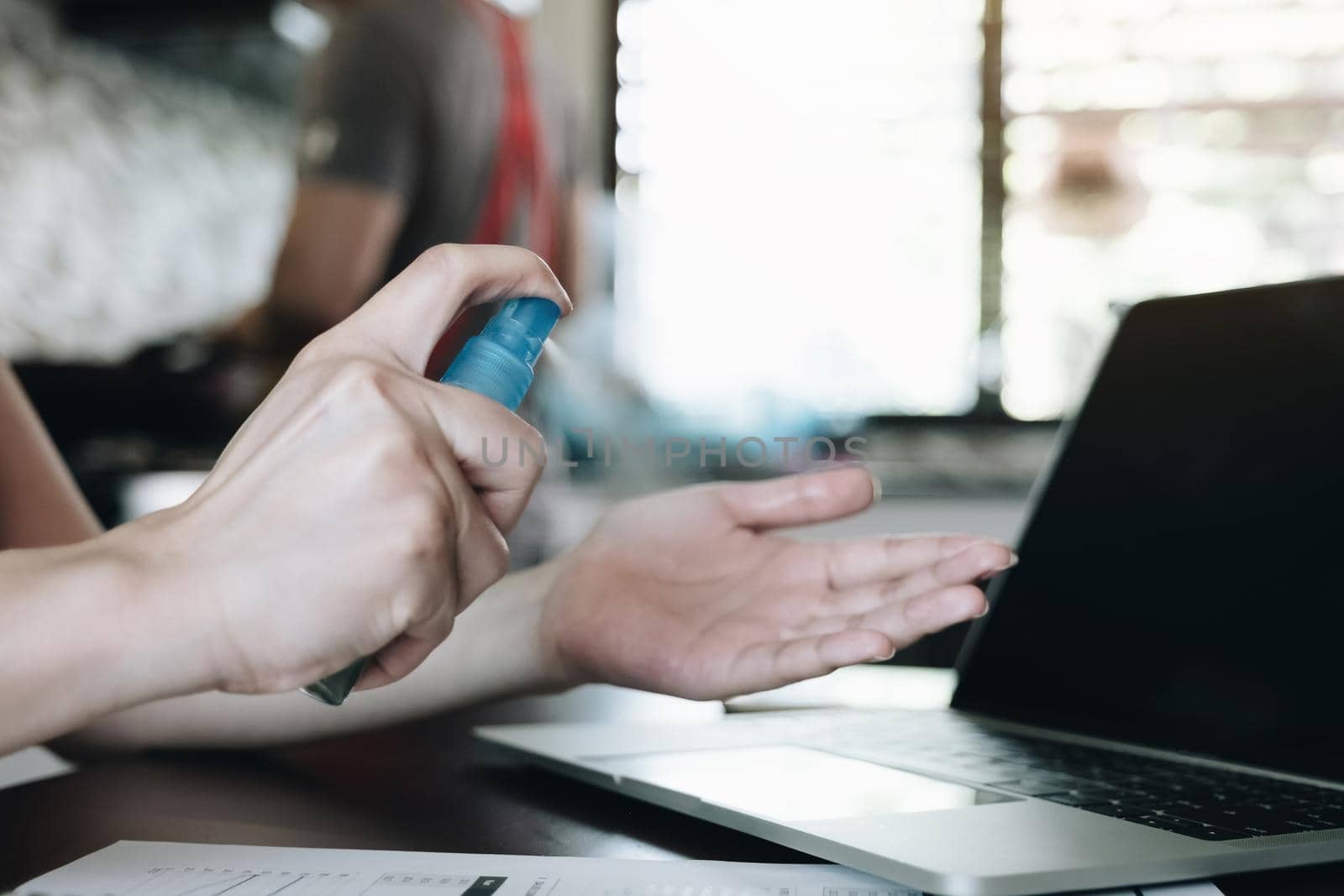 Hand of woman is spraying alcohol,disinfectant spray on hand,prevent infection of Covid-19 virus,contamination of germs or bacteria,wipe or cleaning hand to eliminate,outbreak of Coronavirus
