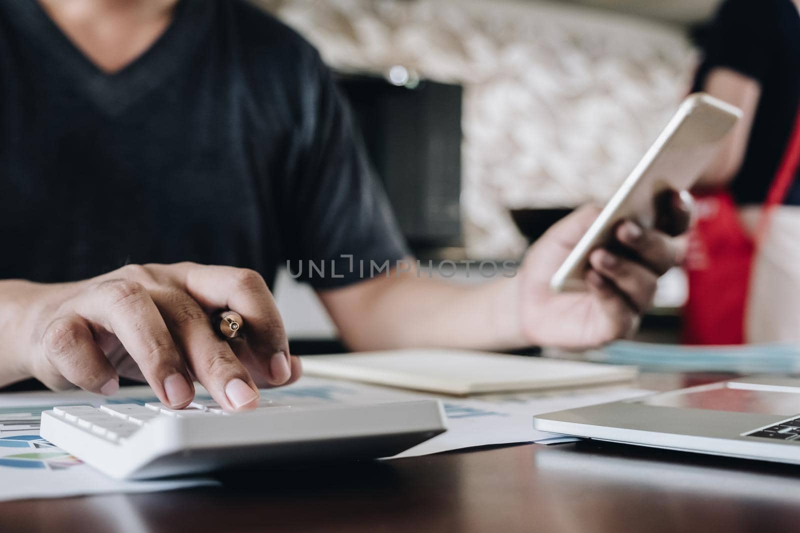 Close up Business woman using calculator and smartphone for do math finance on wooden desk in office and business working background, tax, accounting, statistics and analytic research concept by wichayada