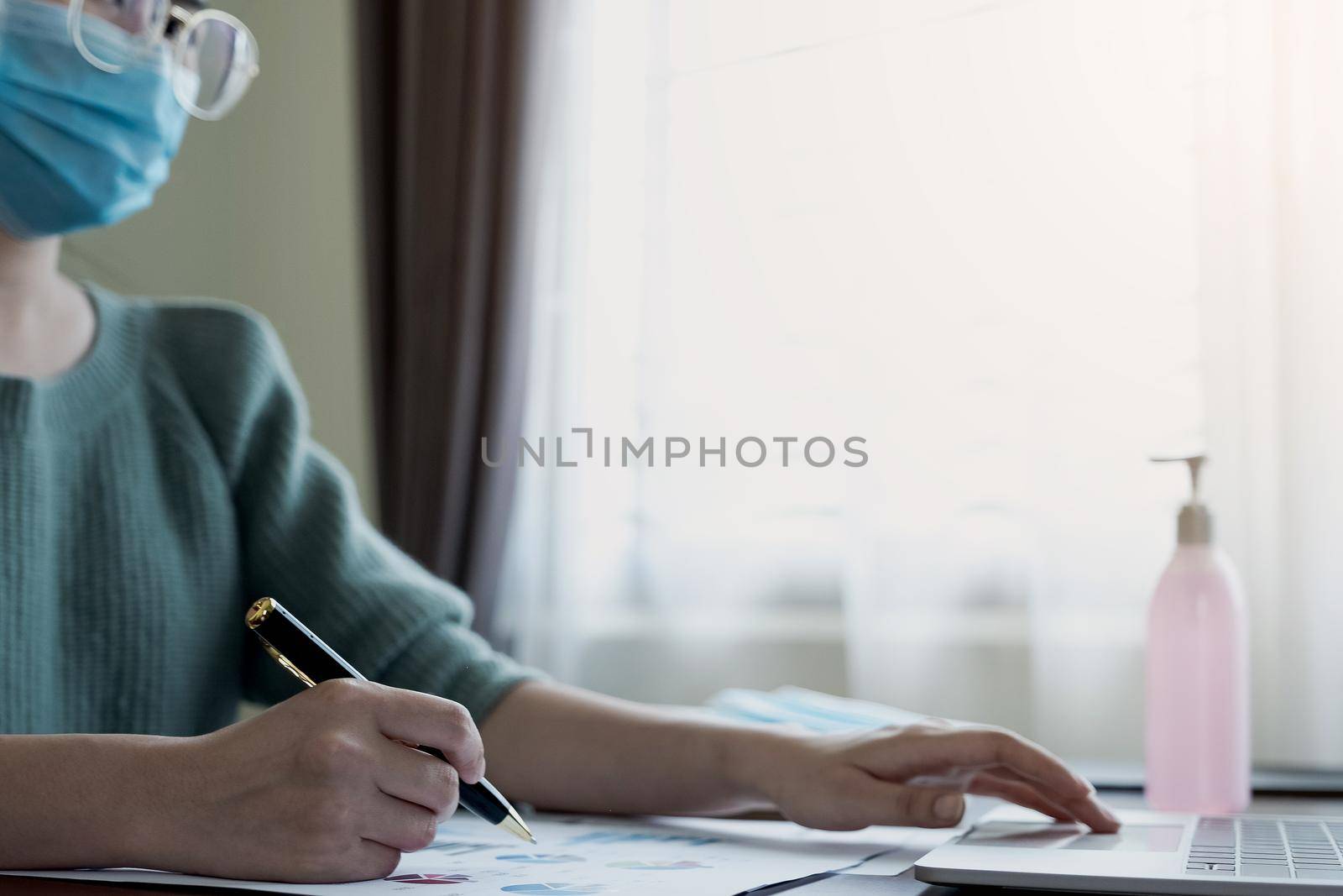 Coronavirus. Business women wear masks to protect and take care of their health. Home working with computer. Working from home.
