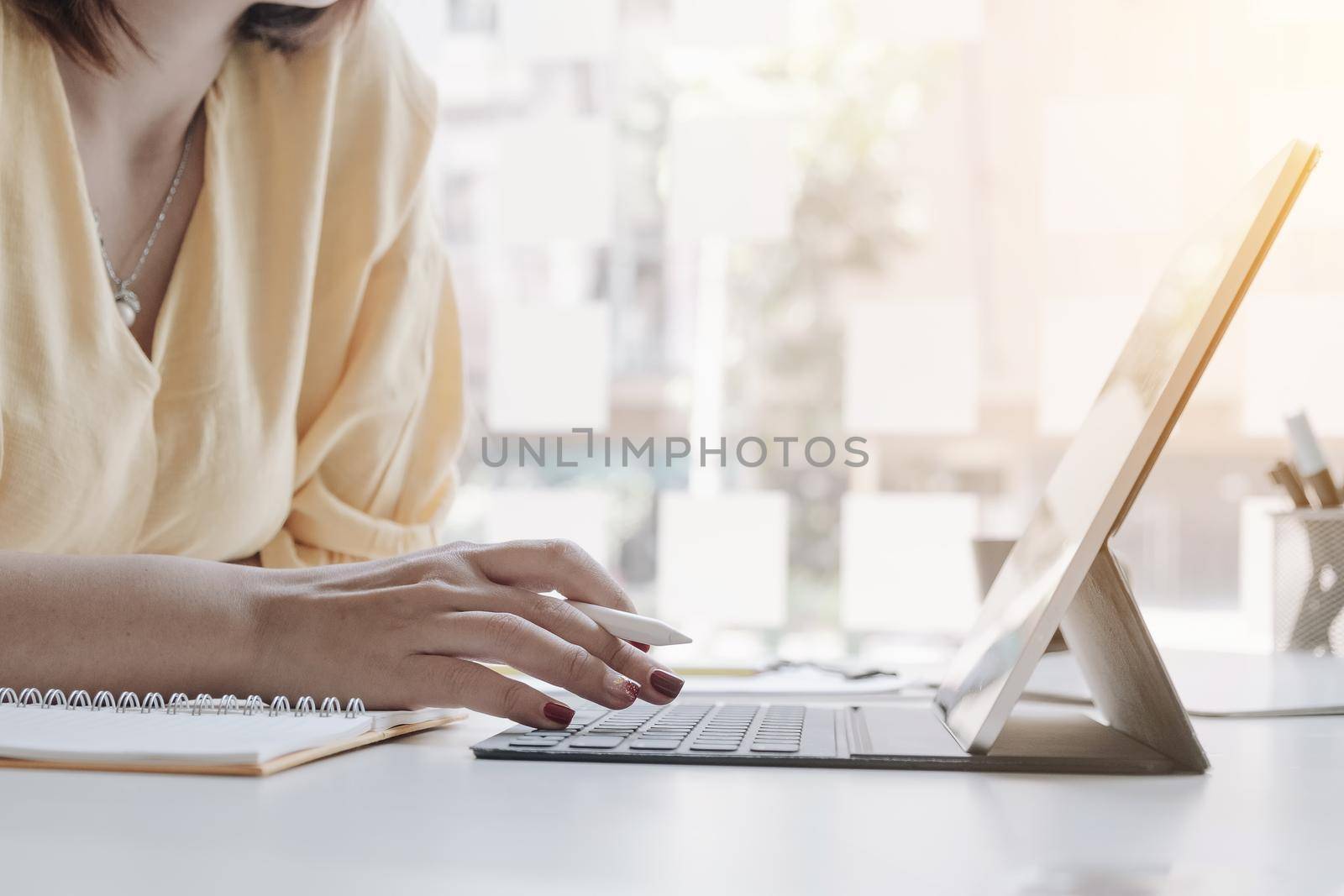 Close up of woman or accountant hand holding pen working on laptop computer for calculate business data, accountancy document and calculator at office, business concept	
