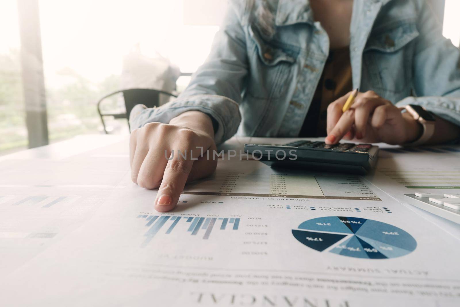 Close up woman Accounting Counting Tax with calculator and financial document report at cafe. by wichayada