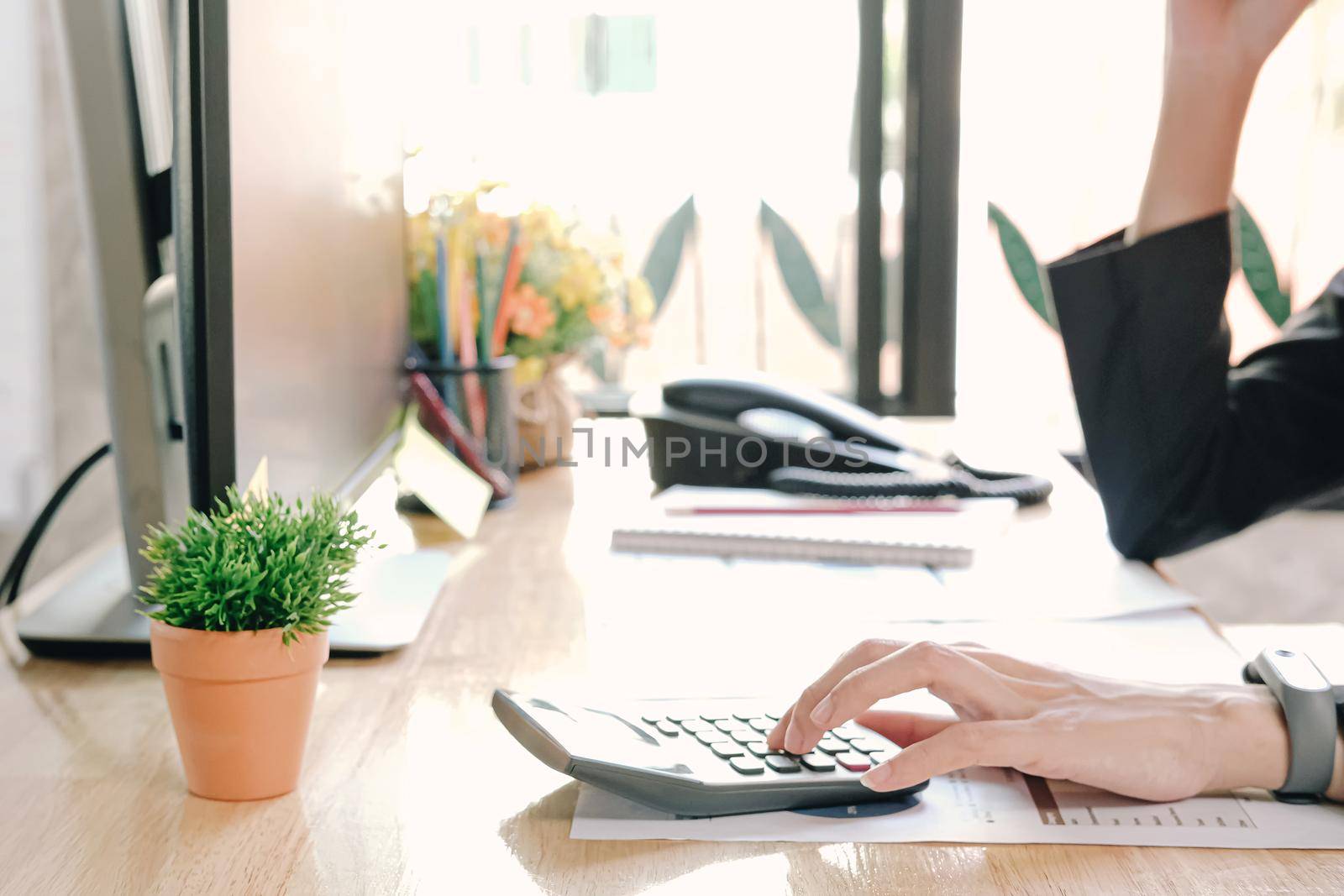 Close up Businesswoman using calculator and laptop for do math finance on wooden desk in office and business working background, tax, accounting, statistics and analytic research concept
