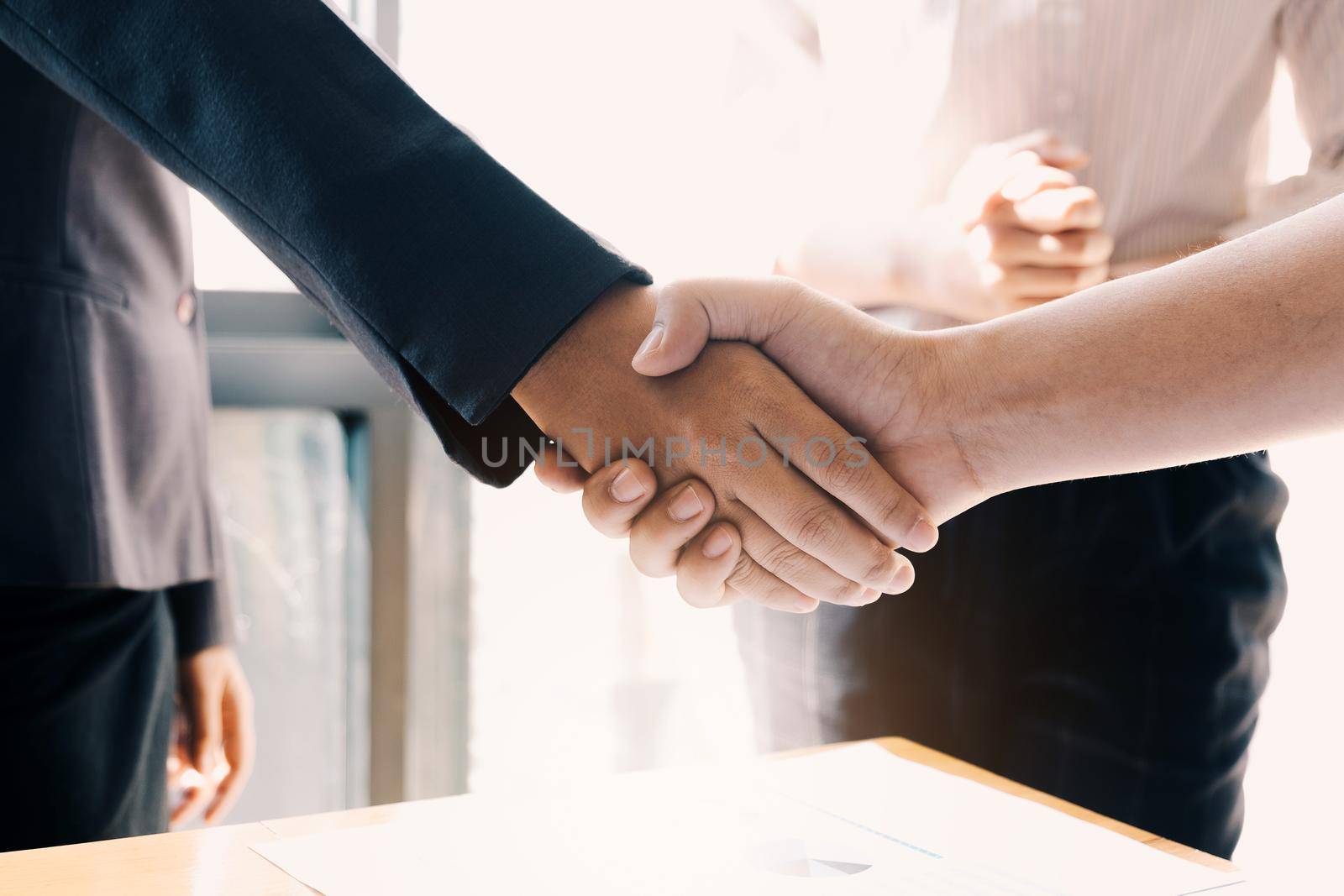 Close up of Business people shaking hands, finishing up meeting, business etiquette, congratulation, merger and acquisition concept by wichayada