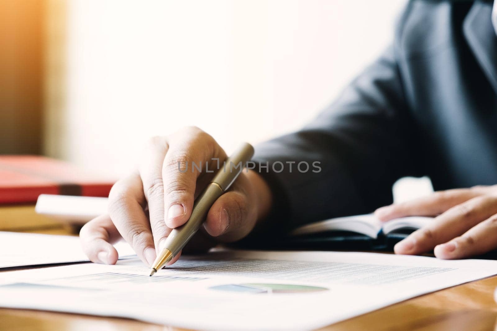 Close up of businessman or accountant hand holding pencil working on calculator to calculate financial data report, accountancy document and laptop computer at office, business concept
