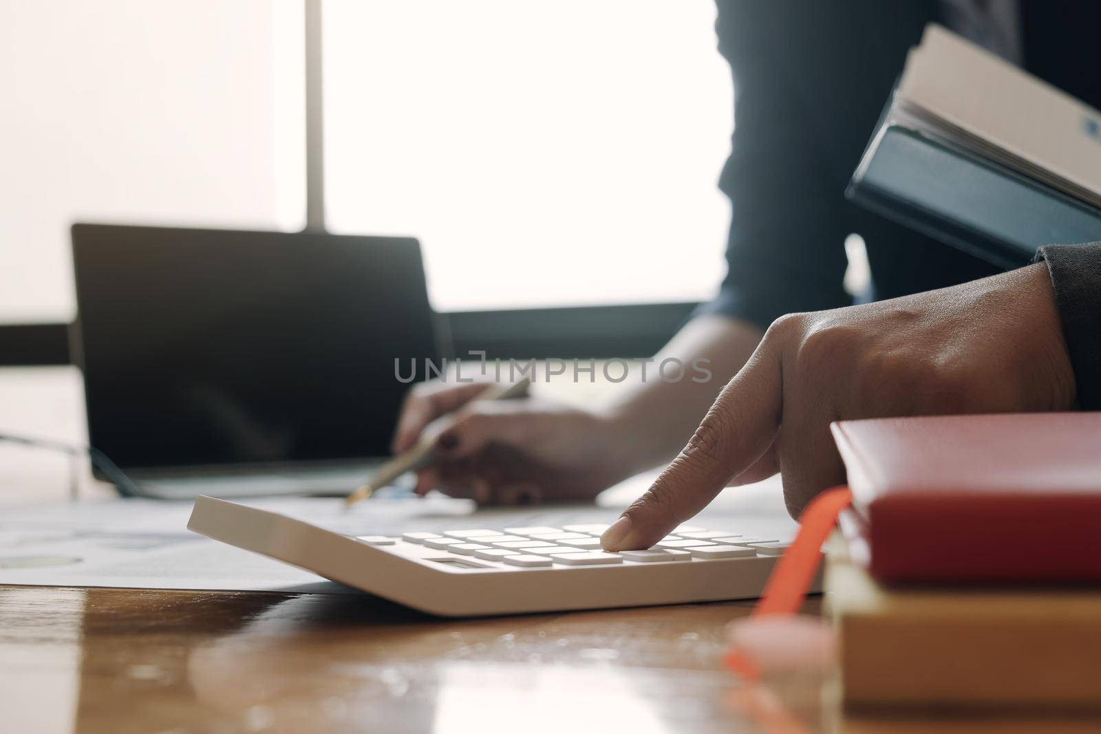 Close up Businessman and partner using calculator and laptop for calaulating finance, tax, accounting, statistics and analytic research concept
