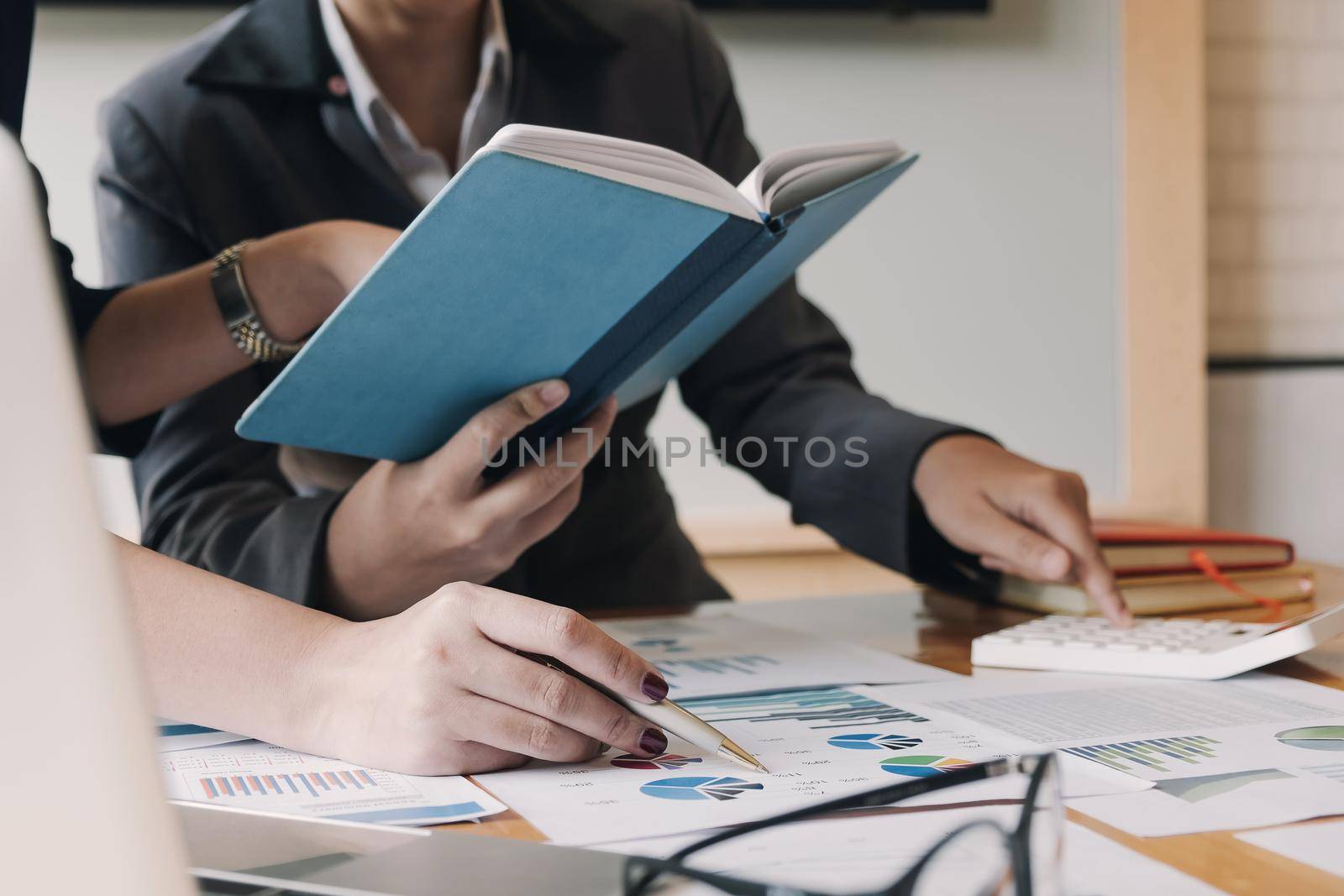 Close up Businessman and partner using calculator and laptop for calaulating finance, tax, accounting, statistics and analytic research concept by wichayada