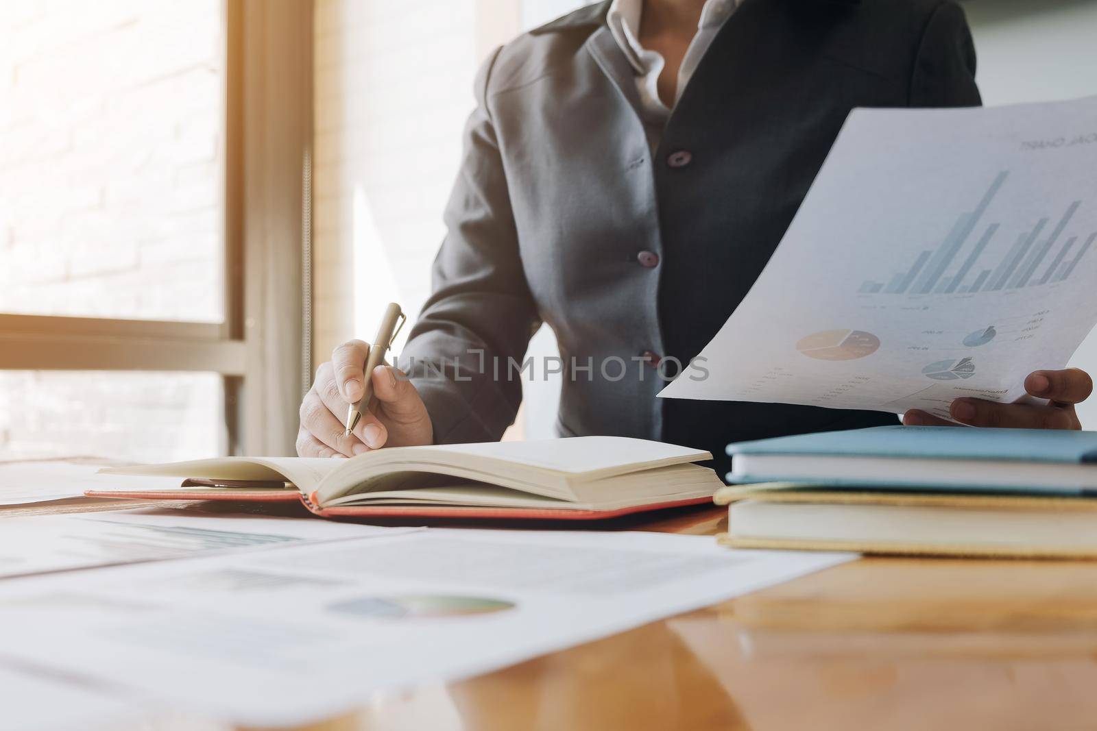 Close up of Business woman investment consultant analysis company annual financial report balance sheet statement working with documents graphs. Concept picture of economy, marketing by wichayada