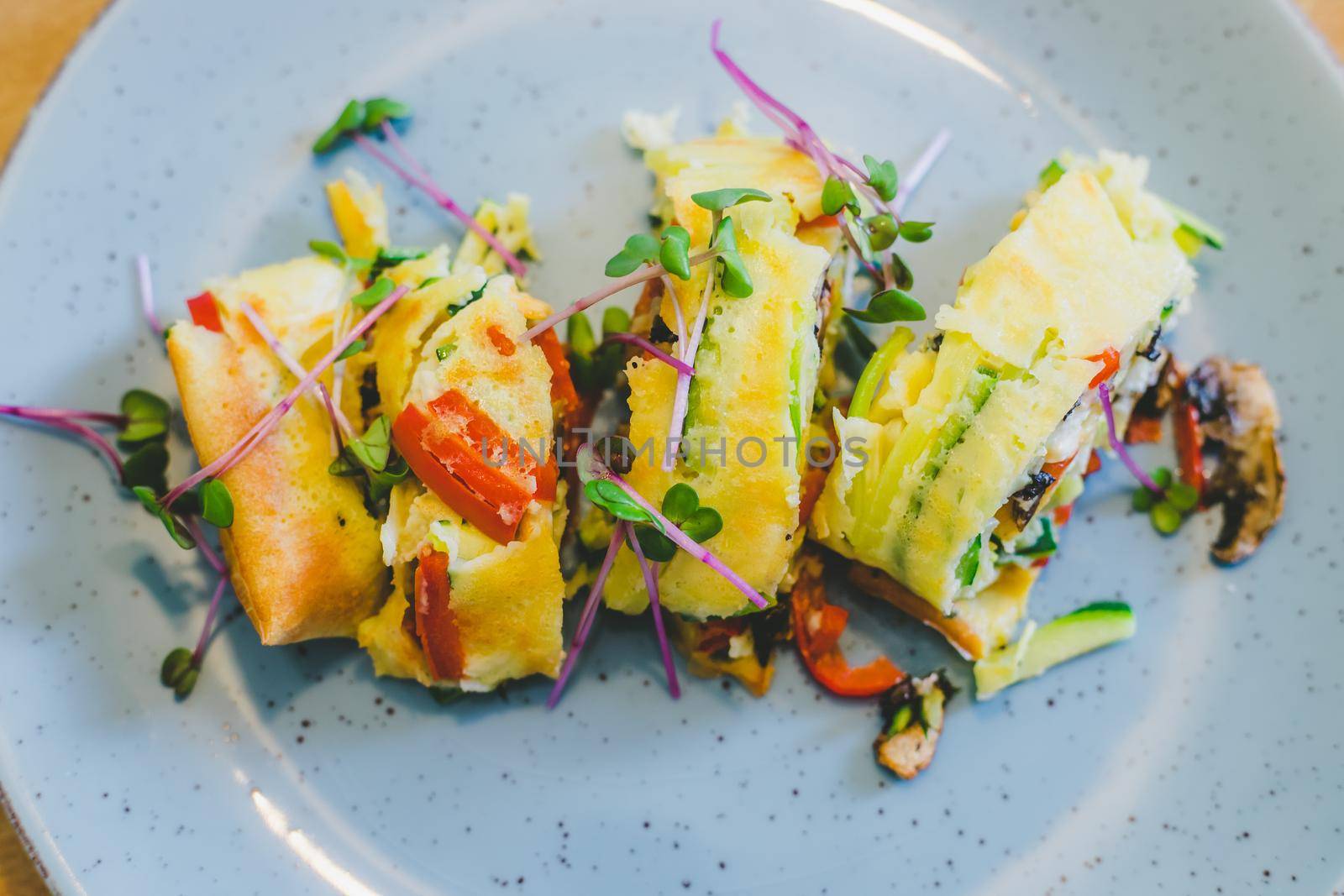 Close up of egg omelet with fresh vegetables. Placed on white ceramic plate.