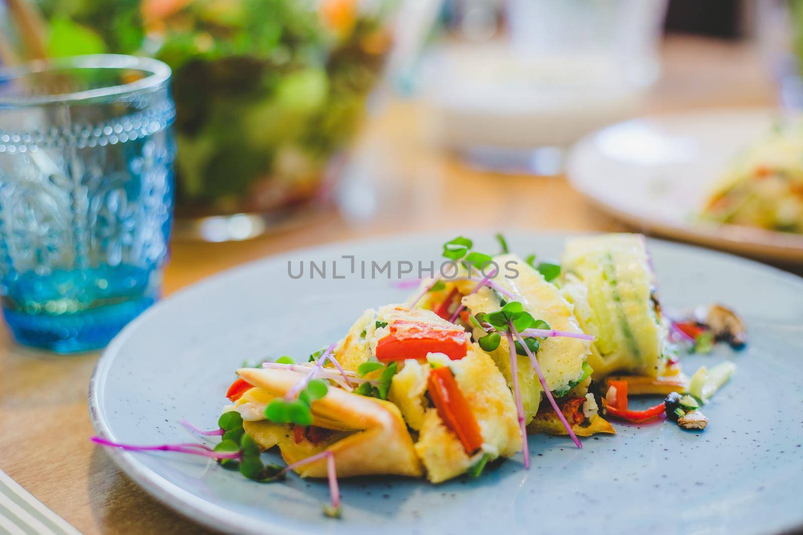 Close up of egg omelet with fresh vegetables. Placed on white ceramic plate.