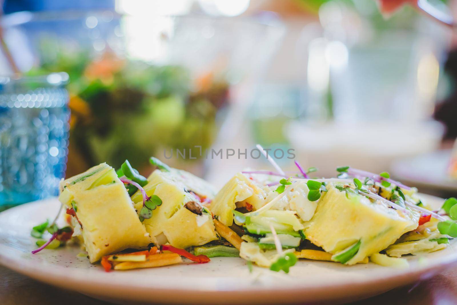 Close up of egg omelet with fresh vegetables. Placed on white ceramic plate.