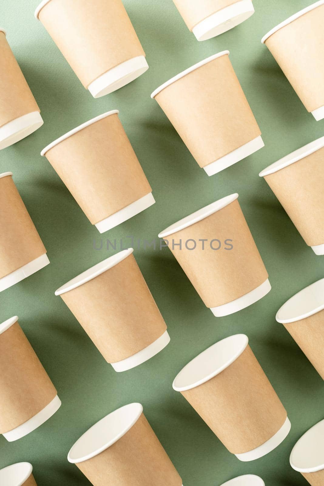 Reusable, disposable and recycling concept. Disposable paper cups pattern top view on green background