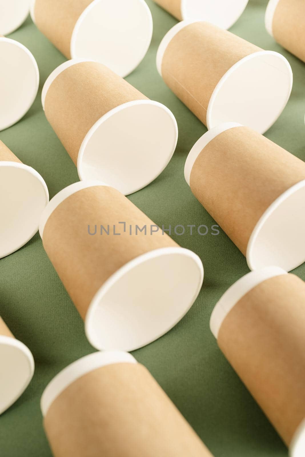 Reusable, disposable and recycling concept. Disposable paper cups pattern top view on green background