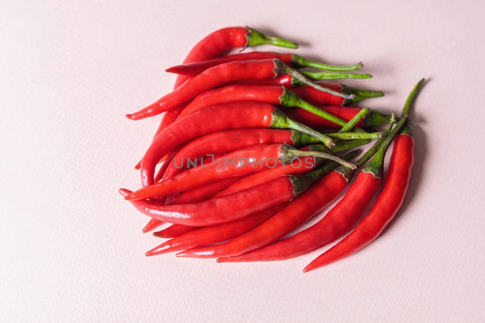 A slide of red chili peppers on a light background. View from above.