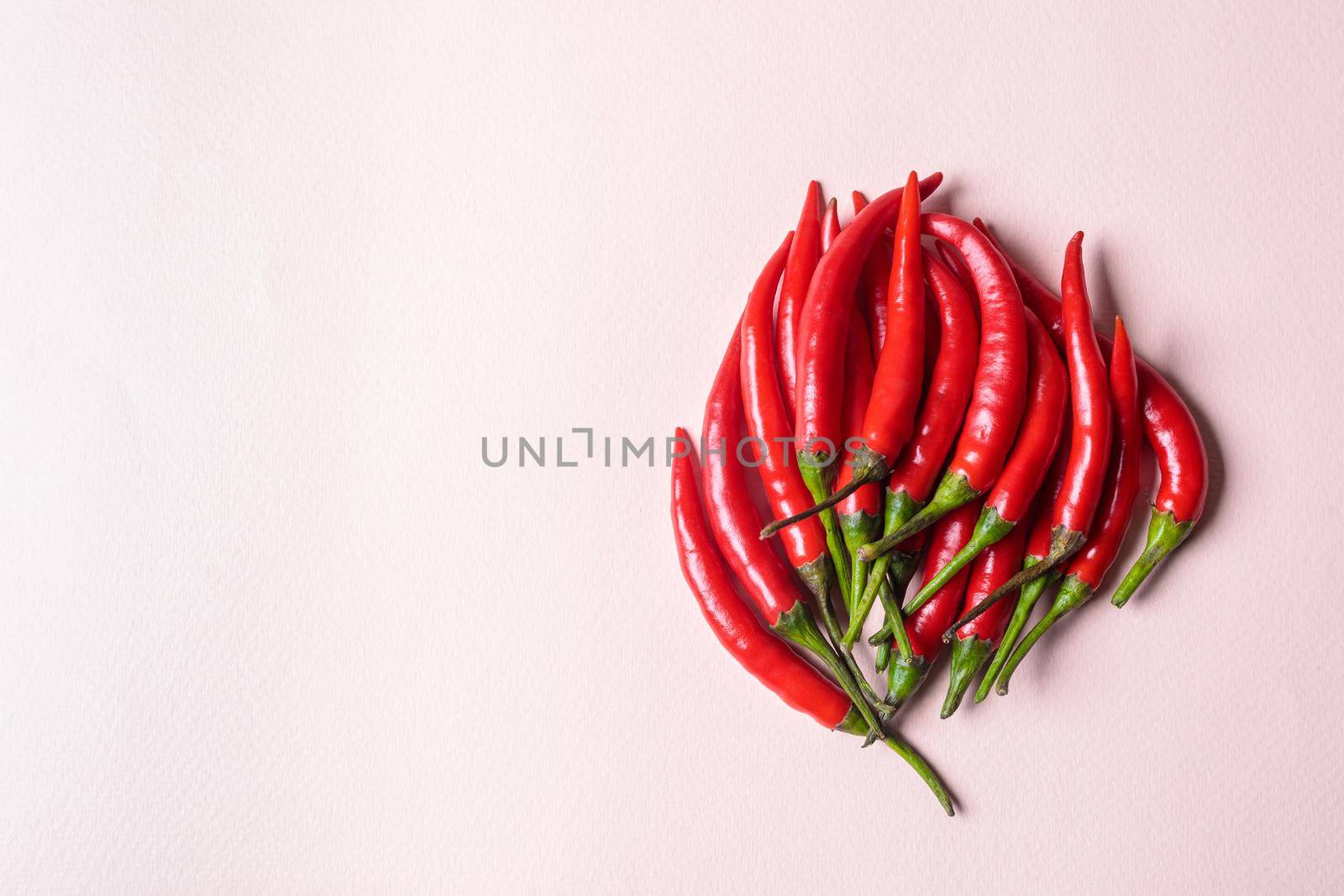 A slide of red chili peppers on a light background. View from above.