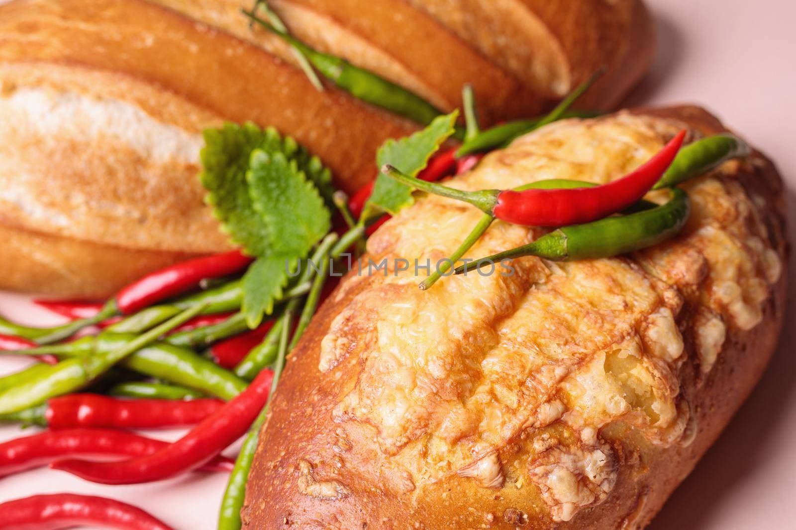 Fresh bread on the table with red and green chili peppers. Close-up