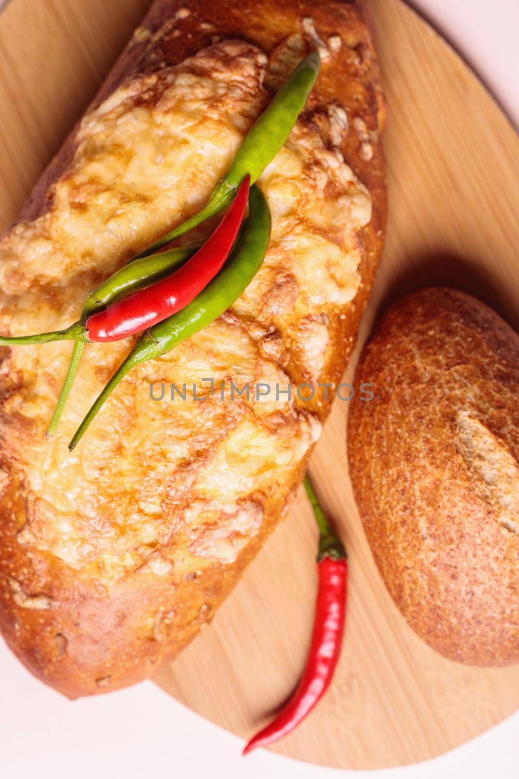 Fresh bread on the table with red and green chili peppers. Close-up