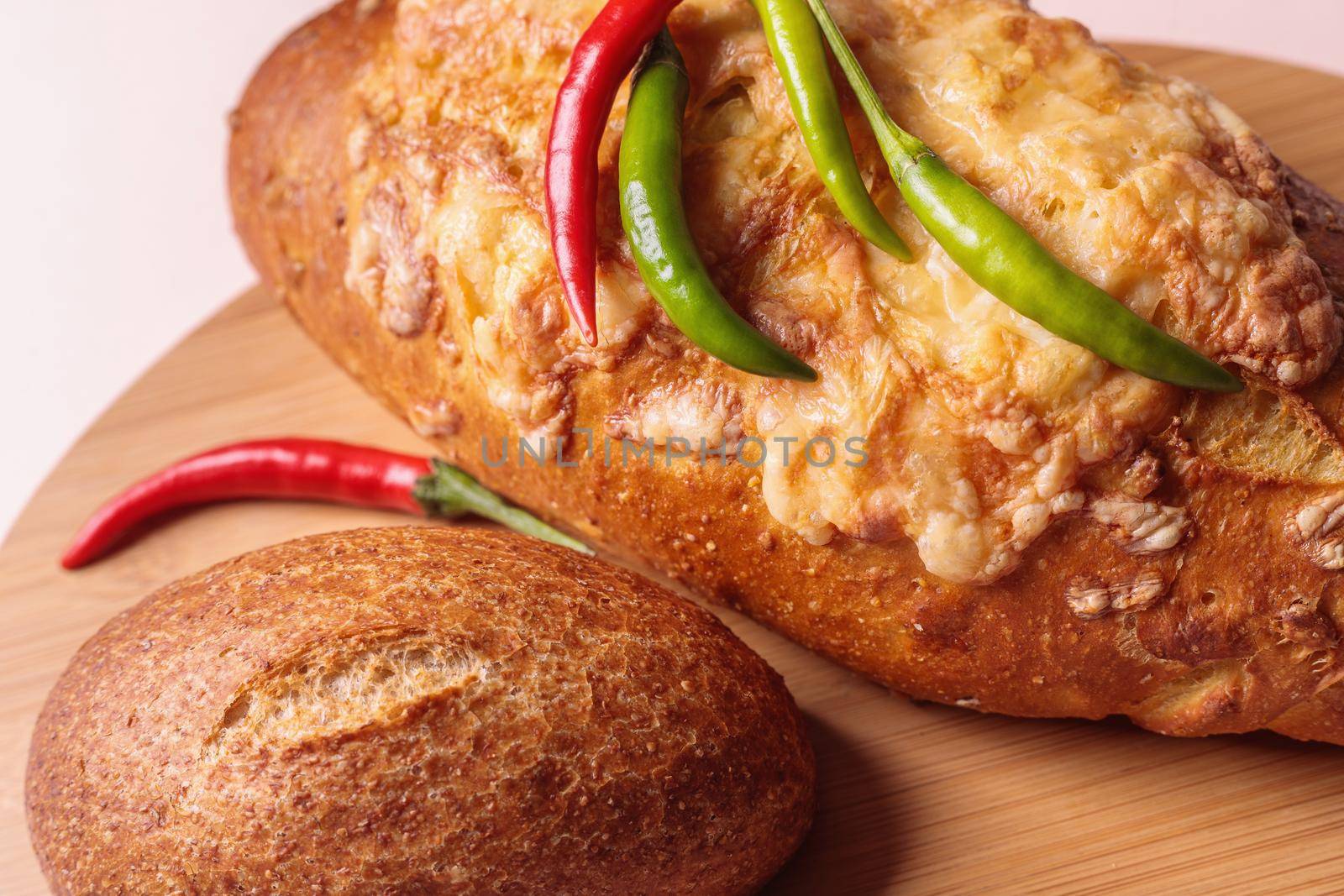 Fresh bread on the table with red and green chili peppers. Close-up