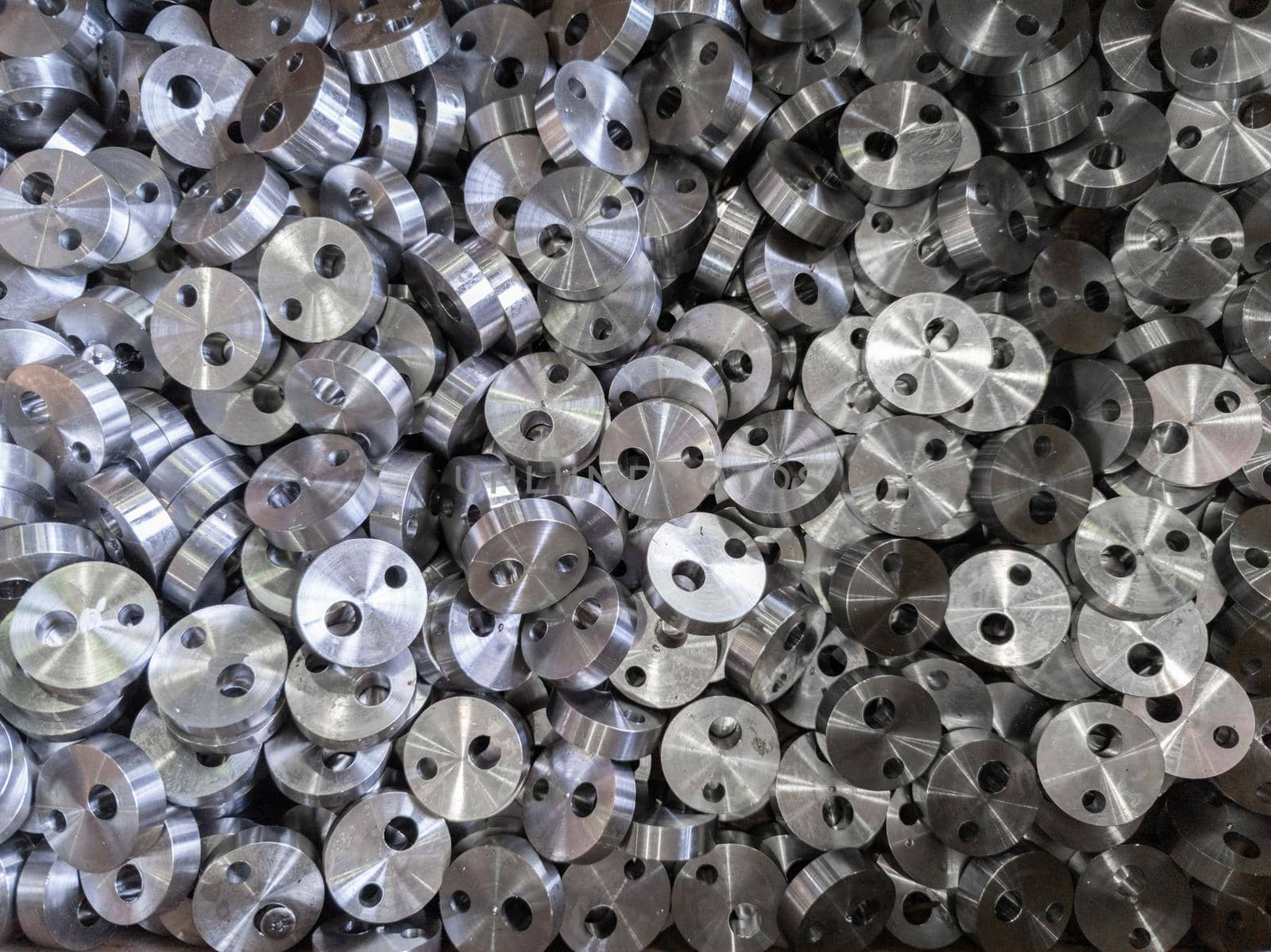 full frame view on heap of round steel cylindrical parts after eccentric drilling.