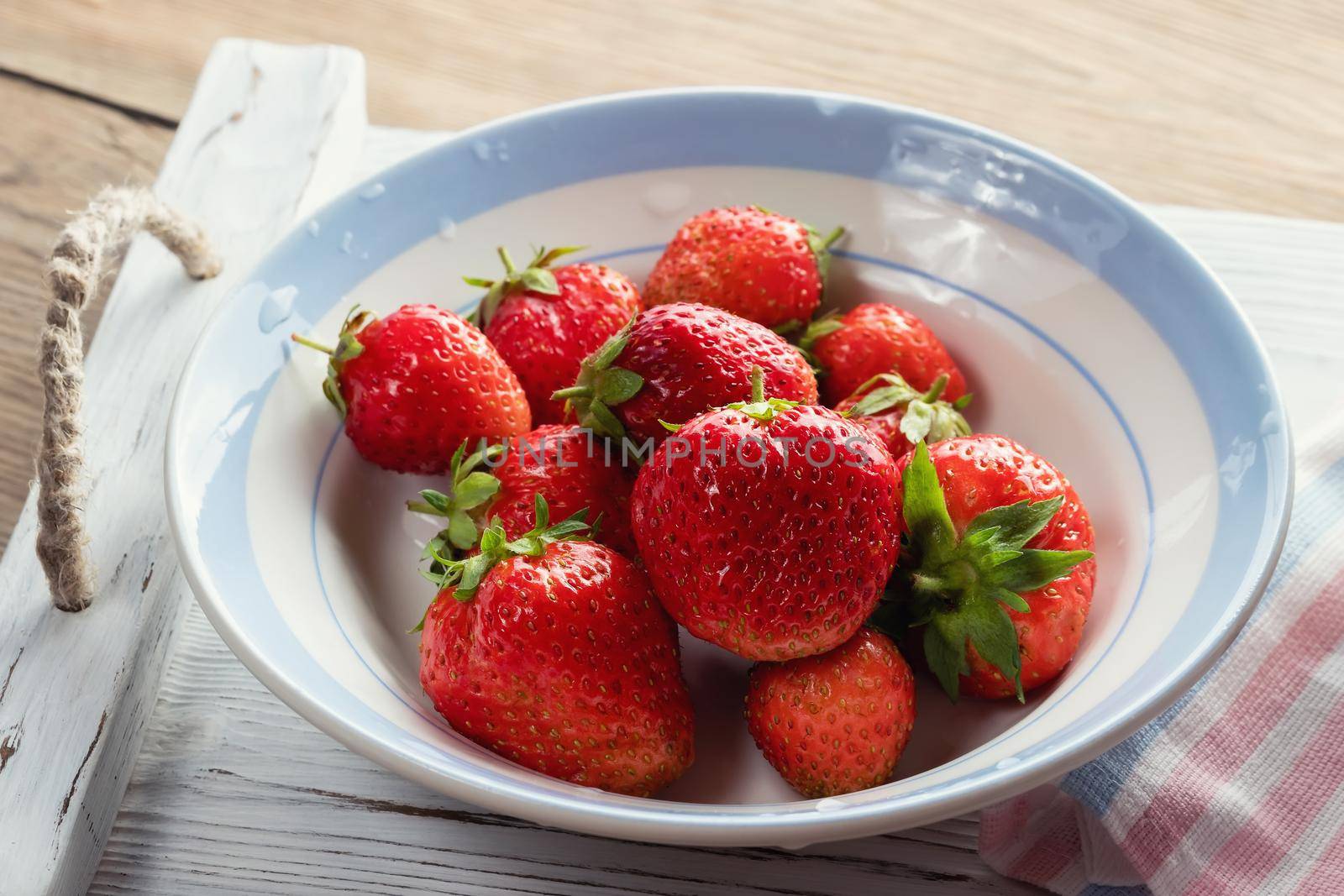 Natural ripe strawberries in a bowl on a wooden table by galsand