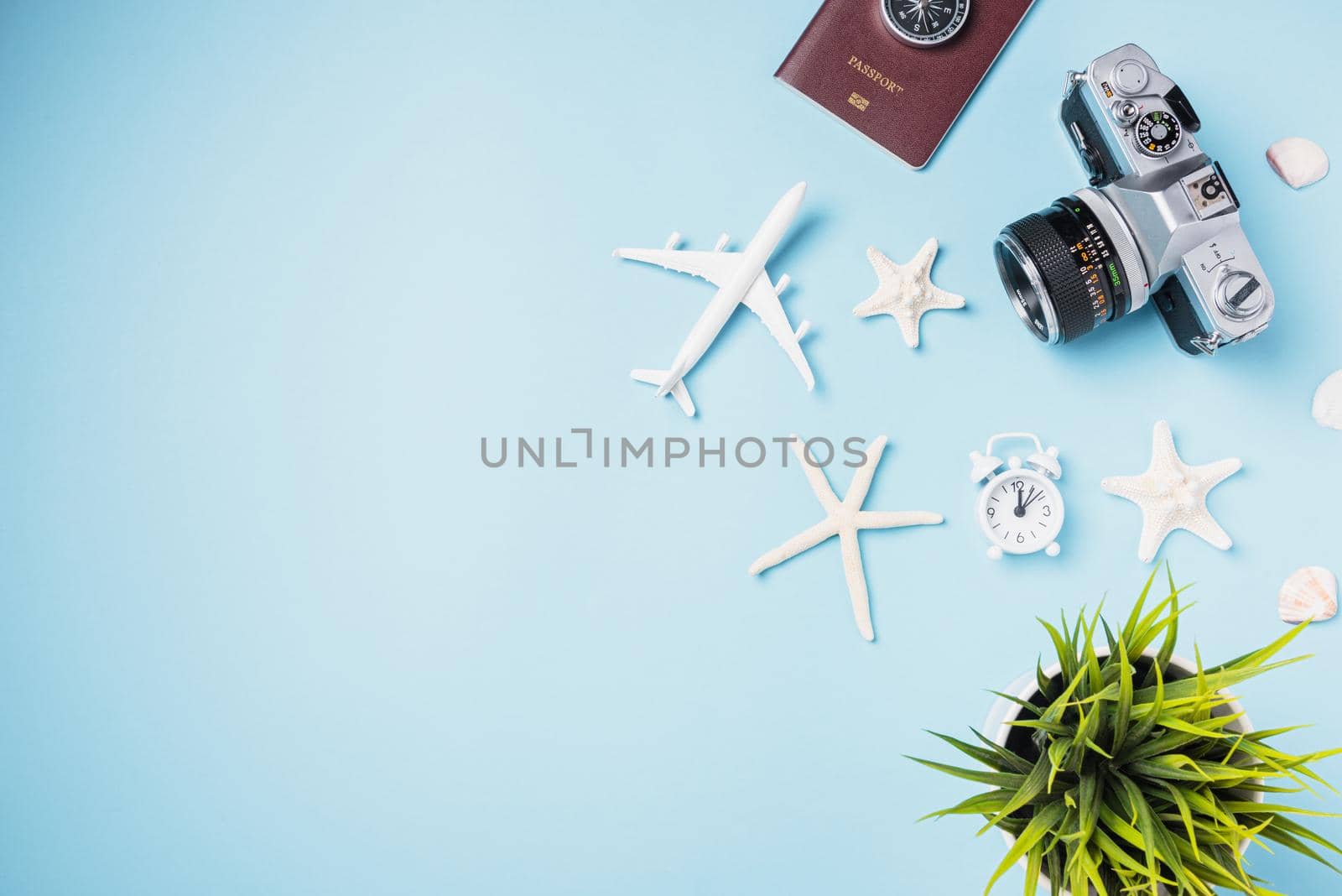 Flat lay top view mockup retro camera films, airplane, starfish, shells, passport traveler tropical accessories on a blue background with copy space, Business trip, and vacation summer travel concept