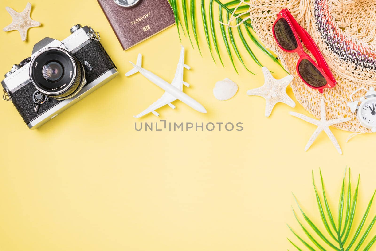 Flat lay top view mockup retro camera films, hat, airplane, starfish traveler tropical beach accessories on a yellow background with copy space, Vacation summer travel and business trip concept