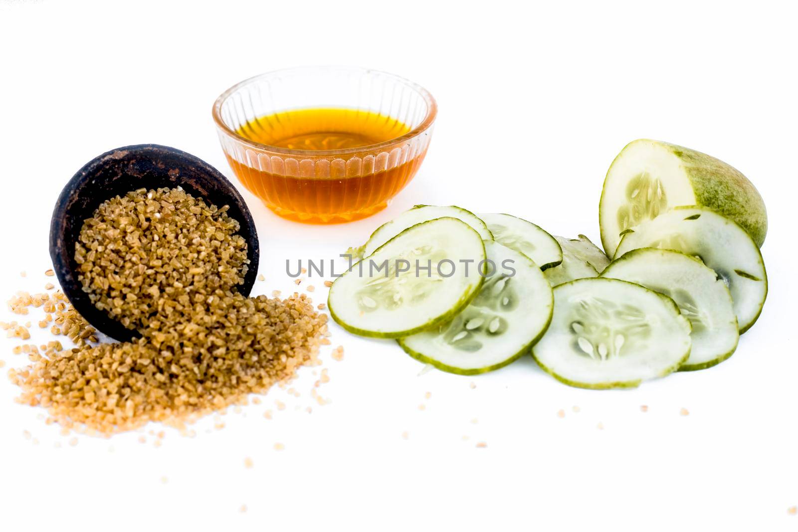 Cucumber face pack or face mask isolated on white with its entire ingredients which are oats and honey along with cucumber pulp well mixed in a glass bowl.Good for dry skin.