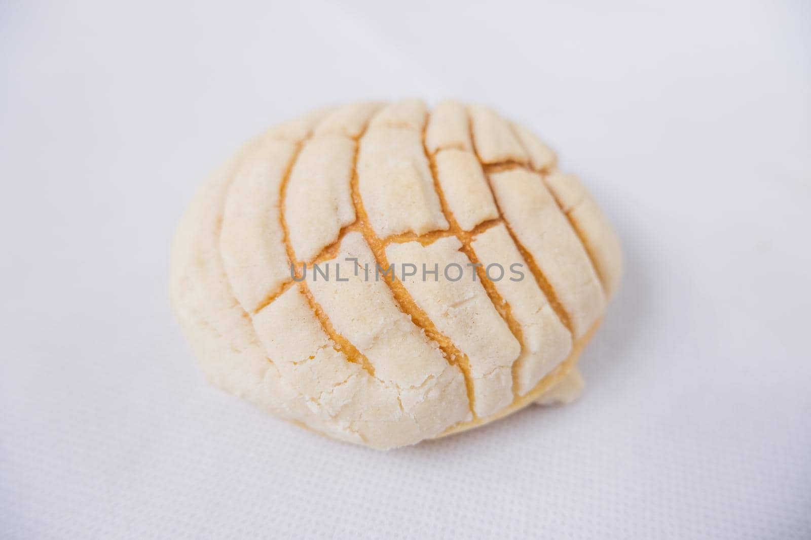 Piece of vanilla sweet bread isolated on white table from above. Top view of classic Mexican bread known as concha on table. Traditional Mexican desserts