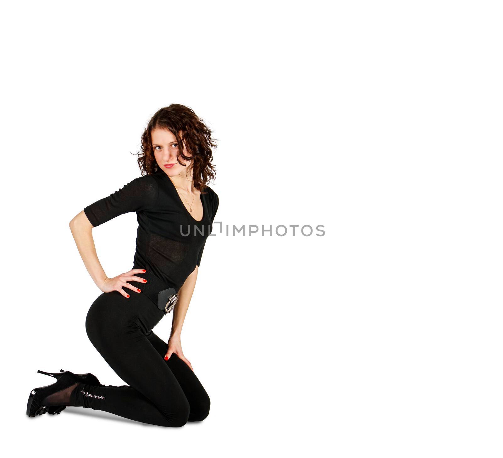 young beautiful woman in black suit posing crouching in studio on white background