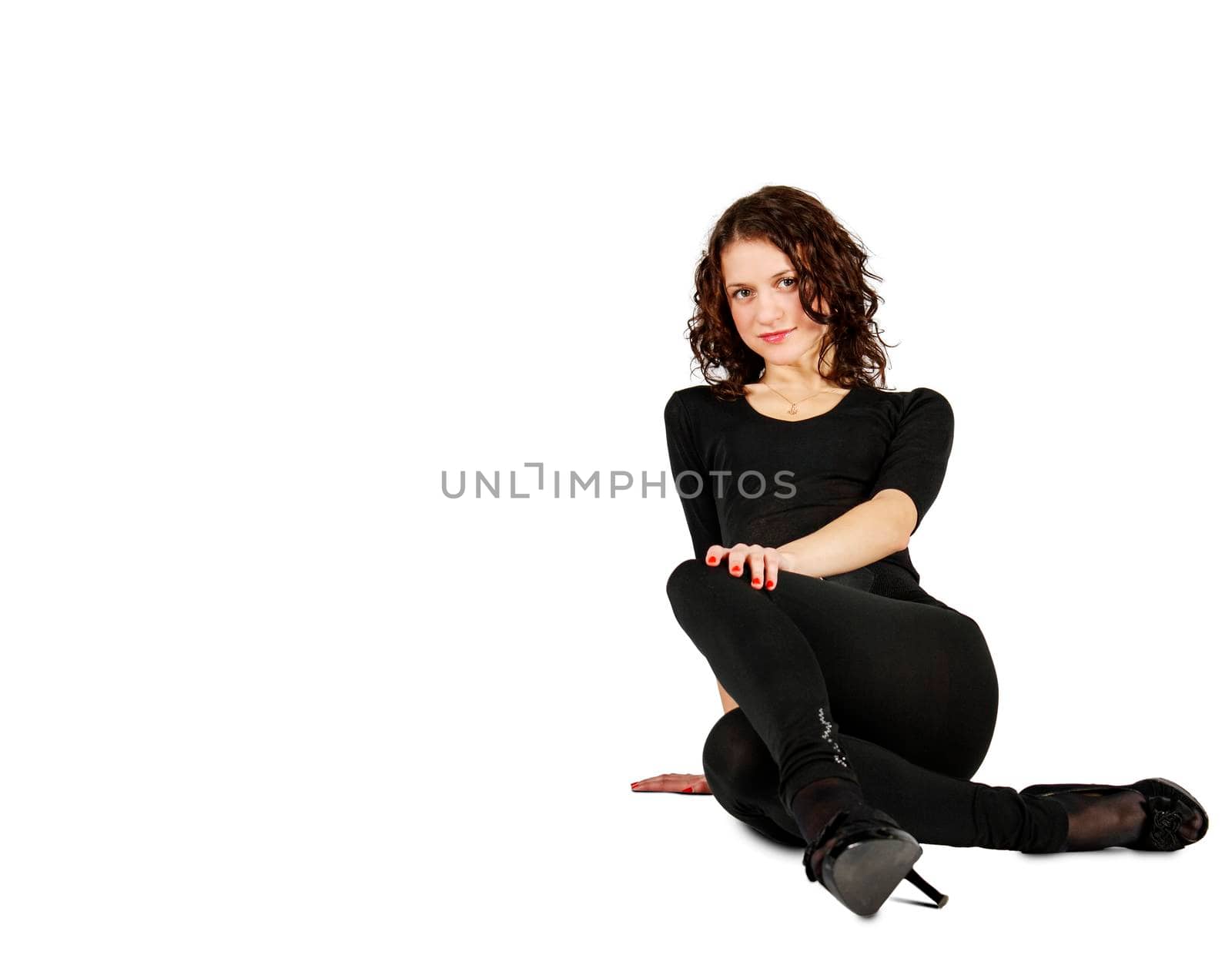 young beautiful woman in black suit posing sitting on the floor in studio on white background