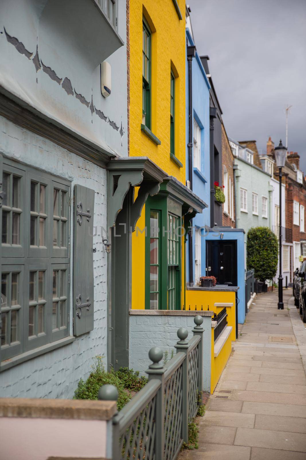 London, UK - February 14, 2020: Row of small colorful British houses with handrails and plants. Beautiful bright color English houses with victorian architecture. Peaceful London neighborhood