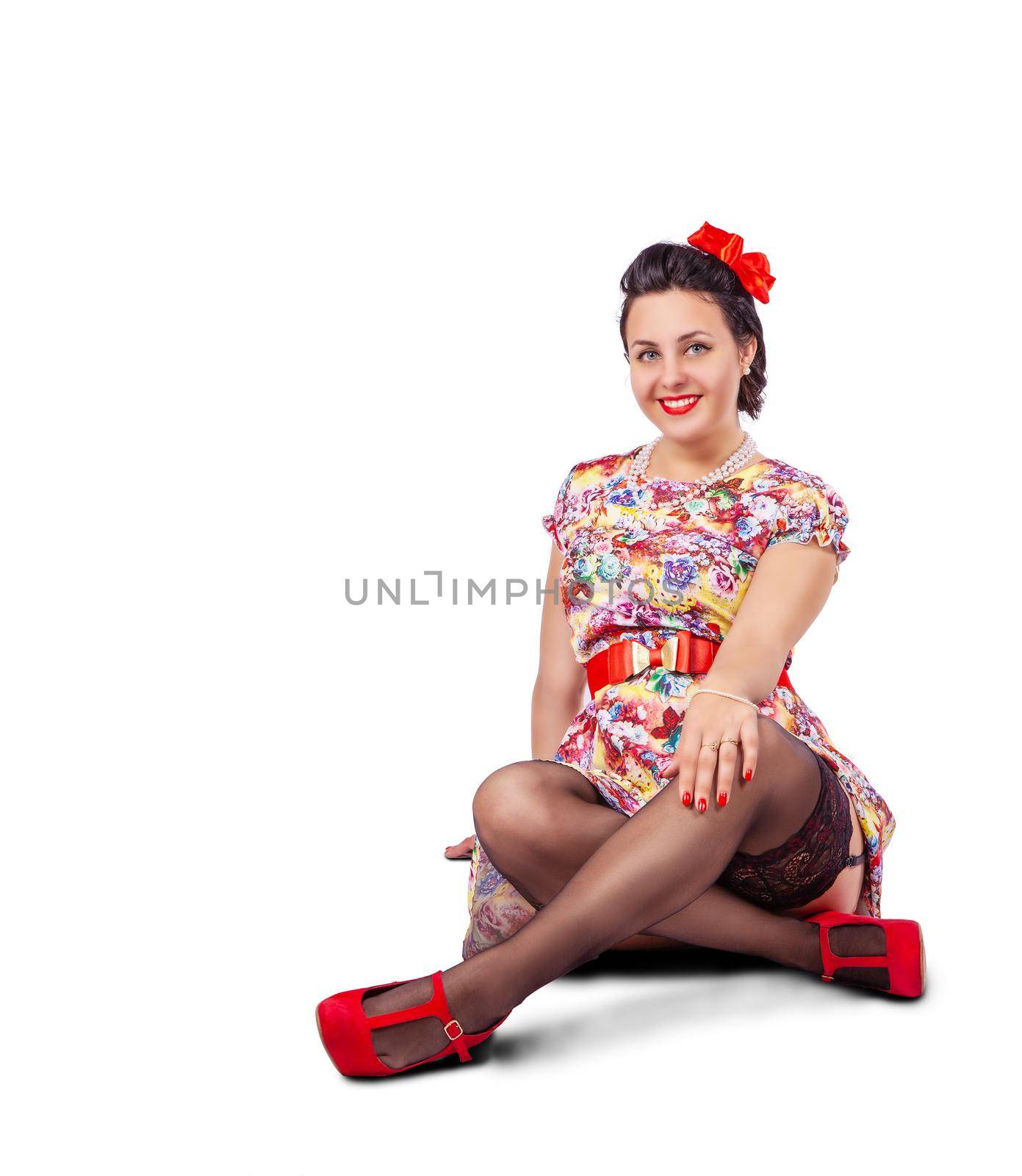 young beautiful woman posing while sitting on the floor in studio on white background. pinup style