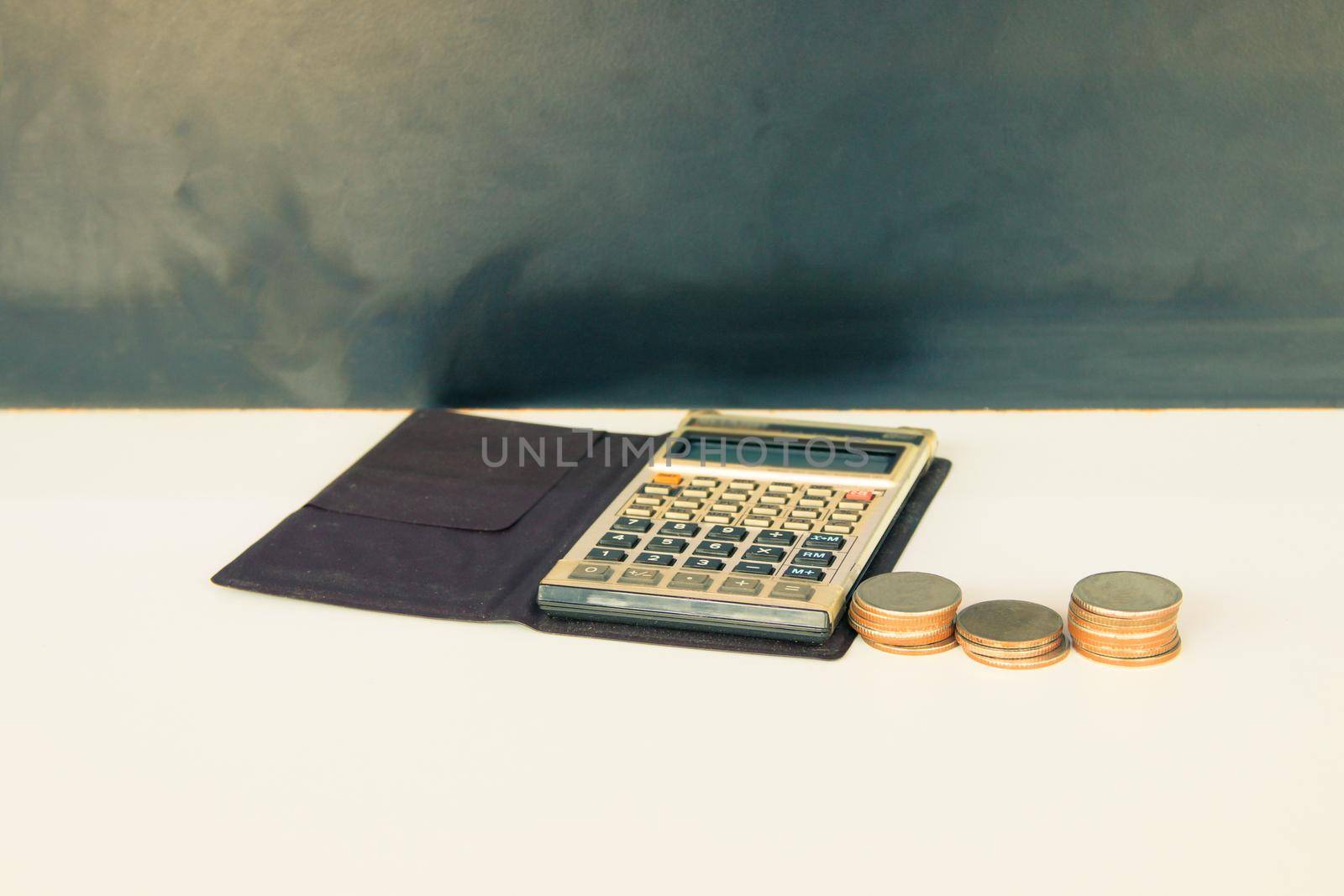 coin money and calculator old, book over white and black background with copy space add text. color vintage style tone