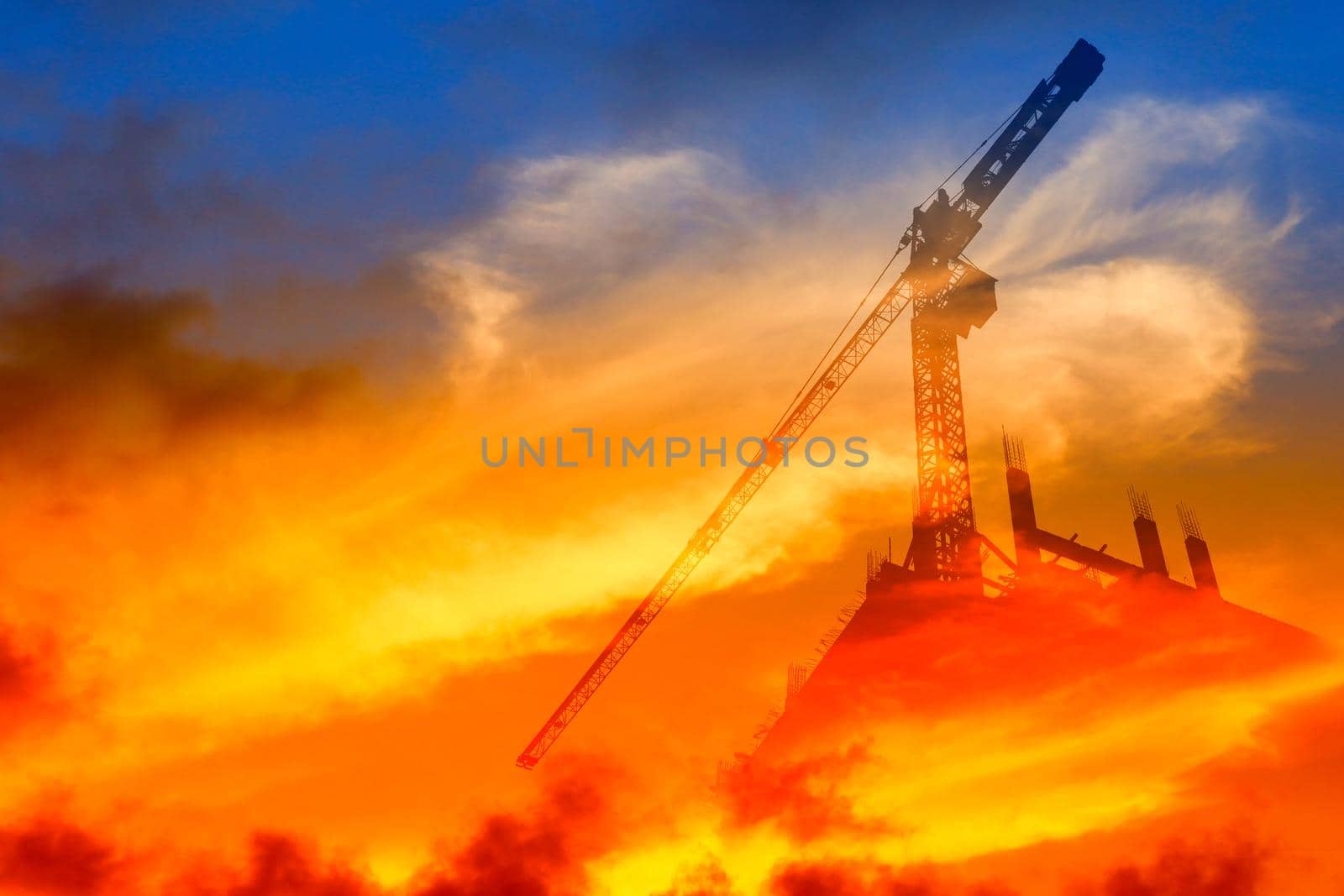 Silhouette Tower crane construction work on sunset time background and copy space add text concept double exposure by pramot