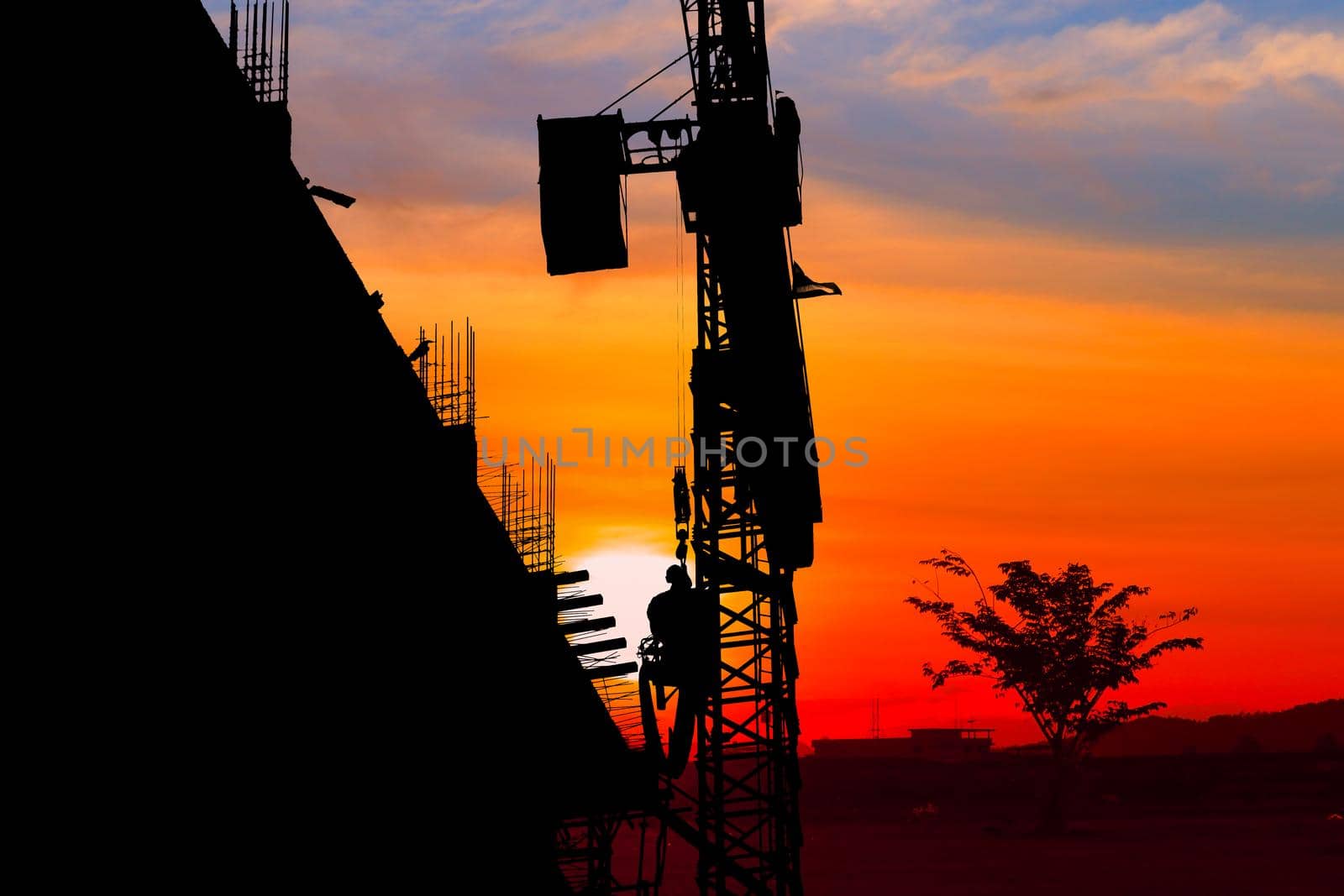 Silhouette Tower crane construction work on sunset-sunrise time background and copy space add text