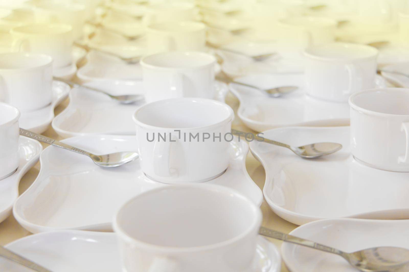 white coffee cup row with saucer and spoon on table