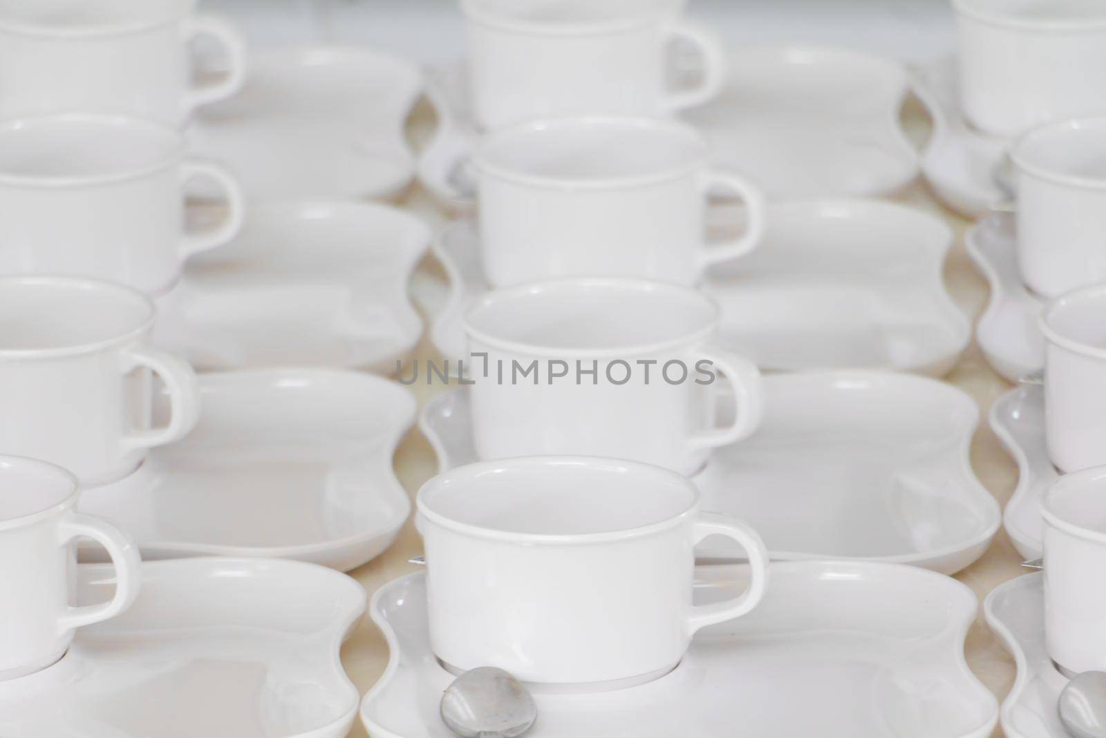white coffee cup row with saucer and spoon on table