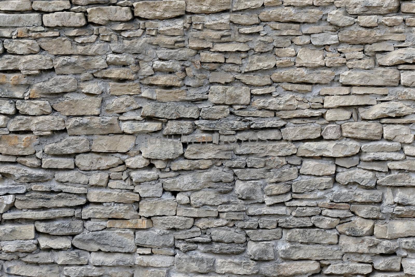 The wall is built of different pieces of stone.Texture or background