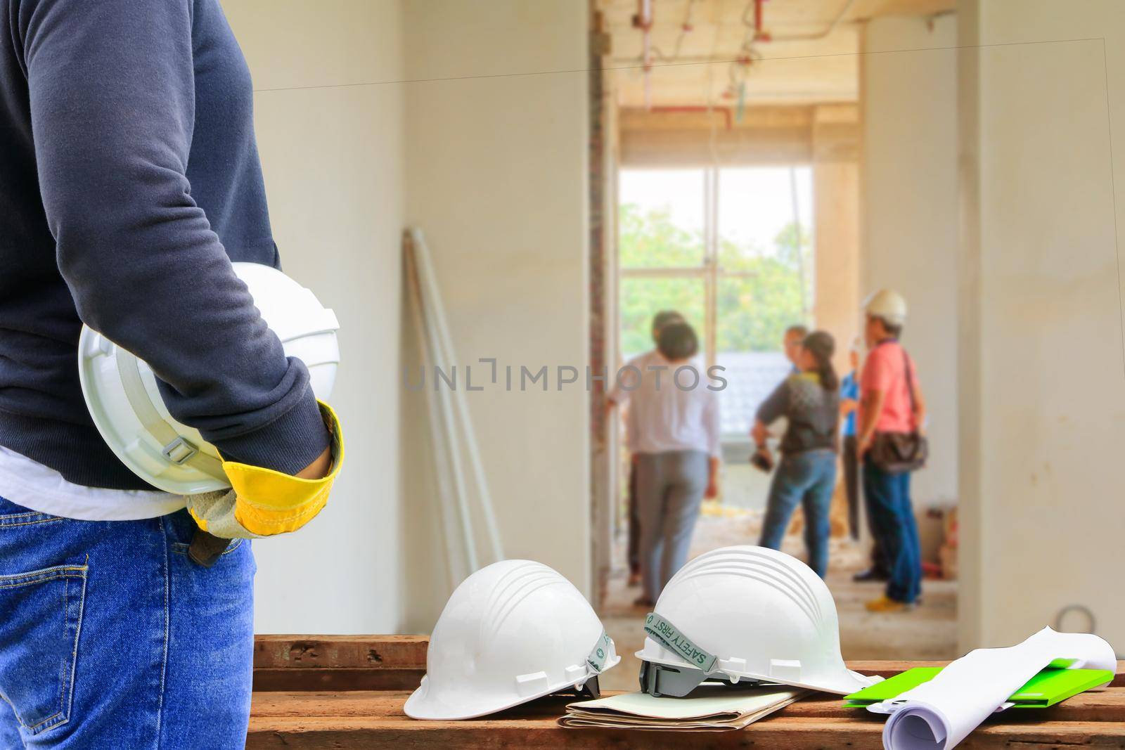 engineering hand holding white safety hat interior working construction site in building  with copy space add text by pramot