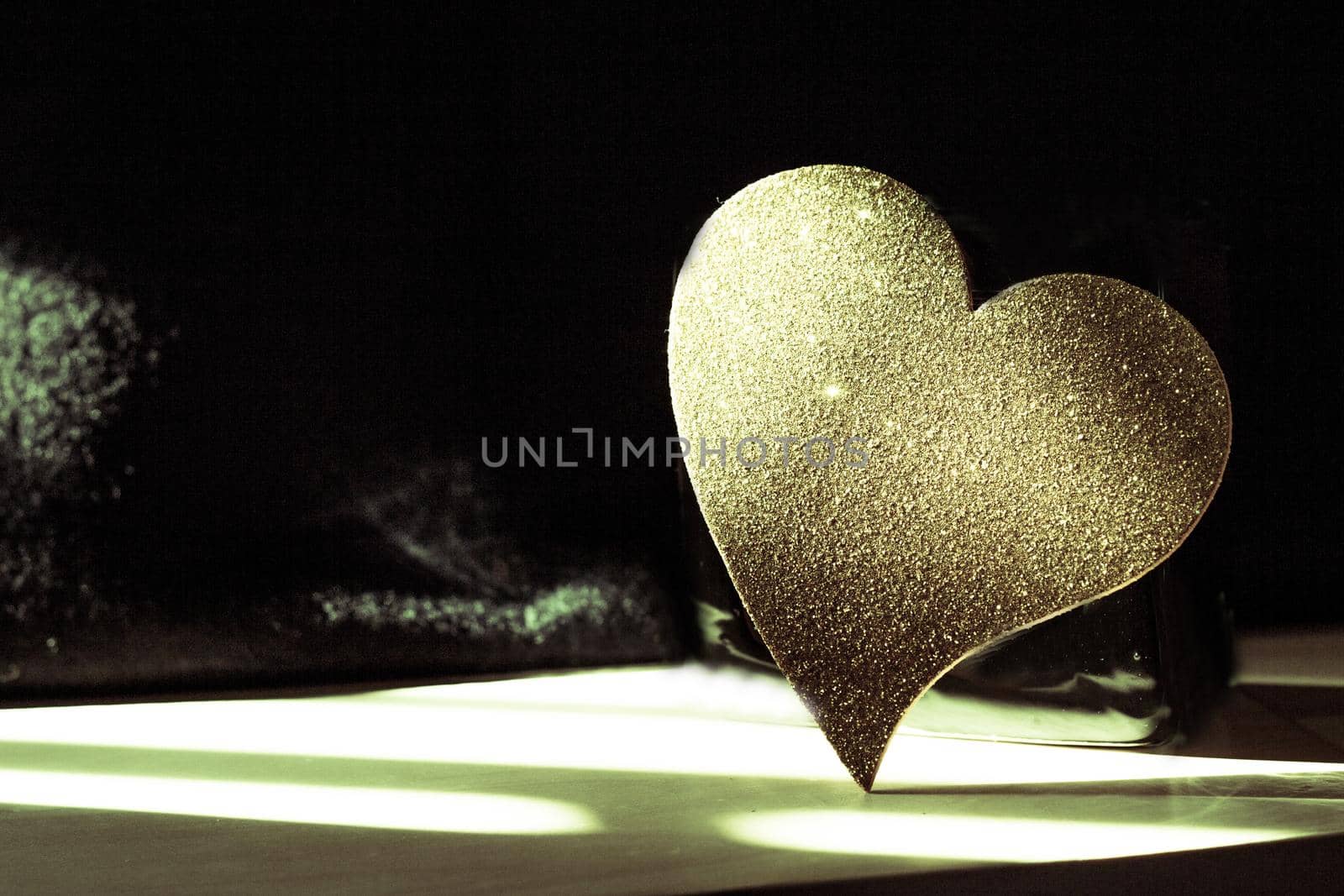 Golden shiny heart on black background