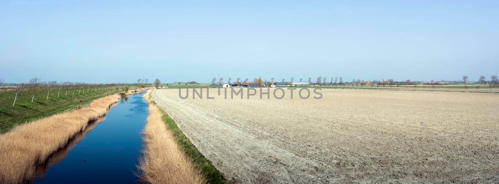 fields and canal in countryside of zeeland in the netherlands by ahavelaar