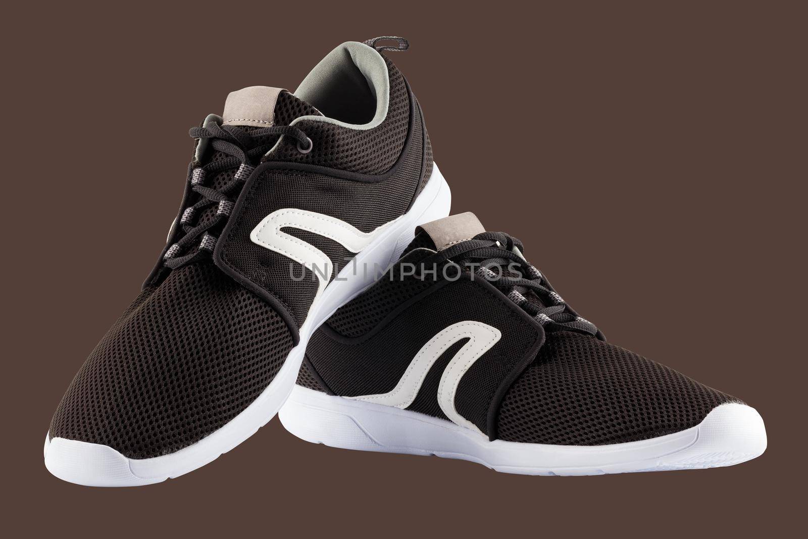 pair of black airmesh summer walking lightweight shoes isolated on brown background.