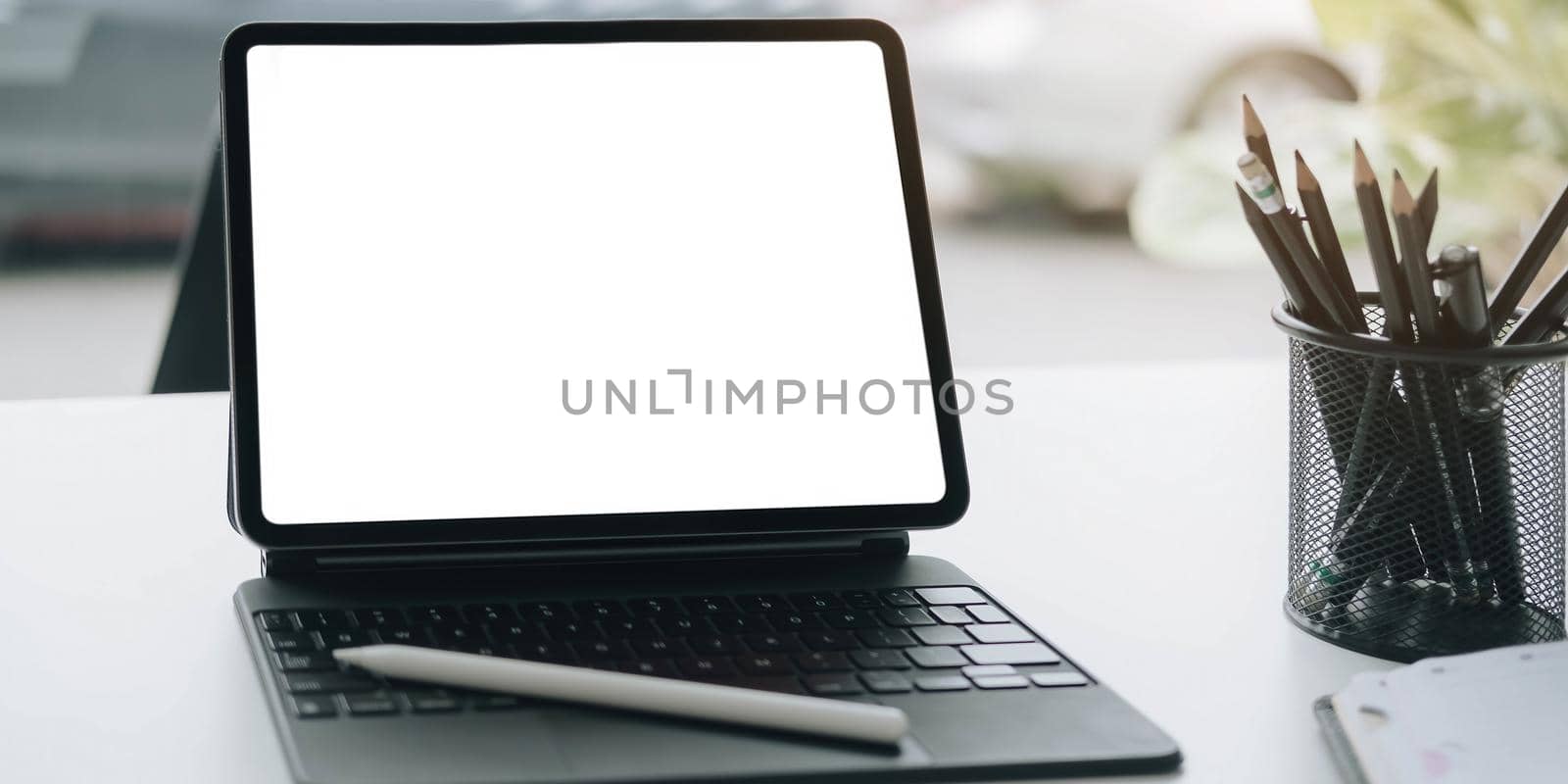 Cropped shot of workplace with tablet blank screen and office supplies in simple workspace. by wichayada