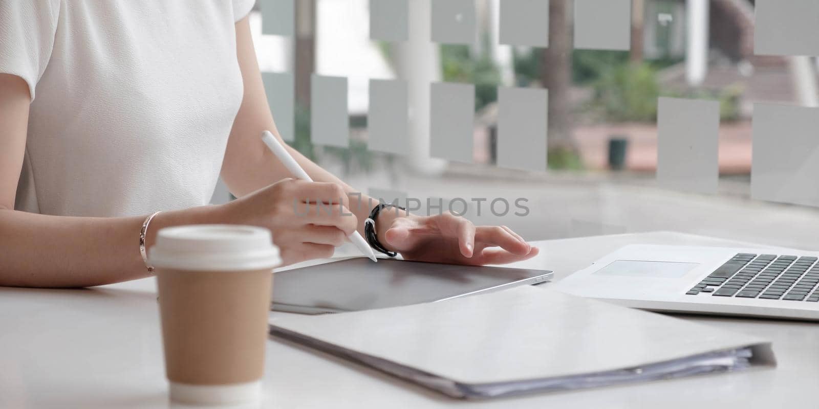 Close up view of female designer hands typing on computer laptop while working at modern startup office..