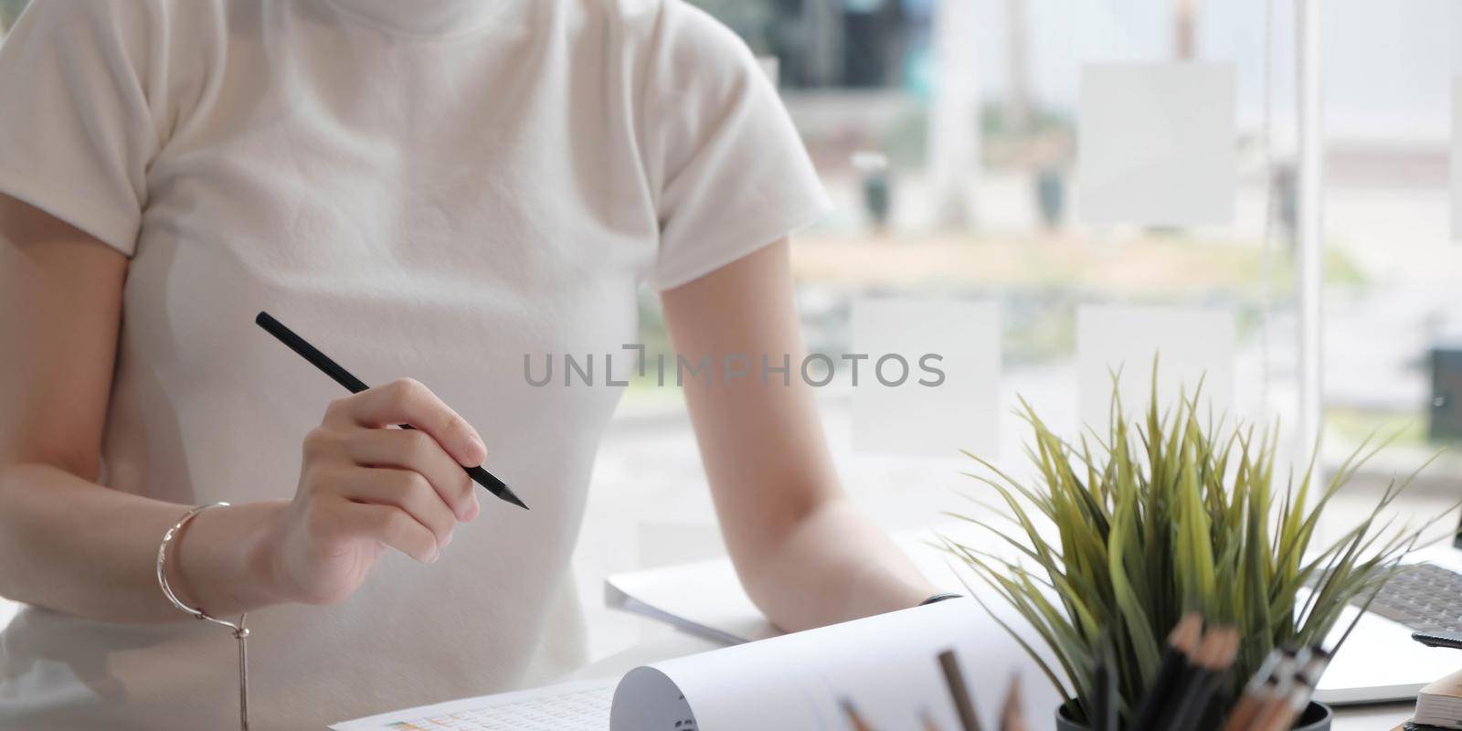 Closeup asian woman writing on notebook on table with laptop, girl work at coffee shop, freelance business concept. by wichayada